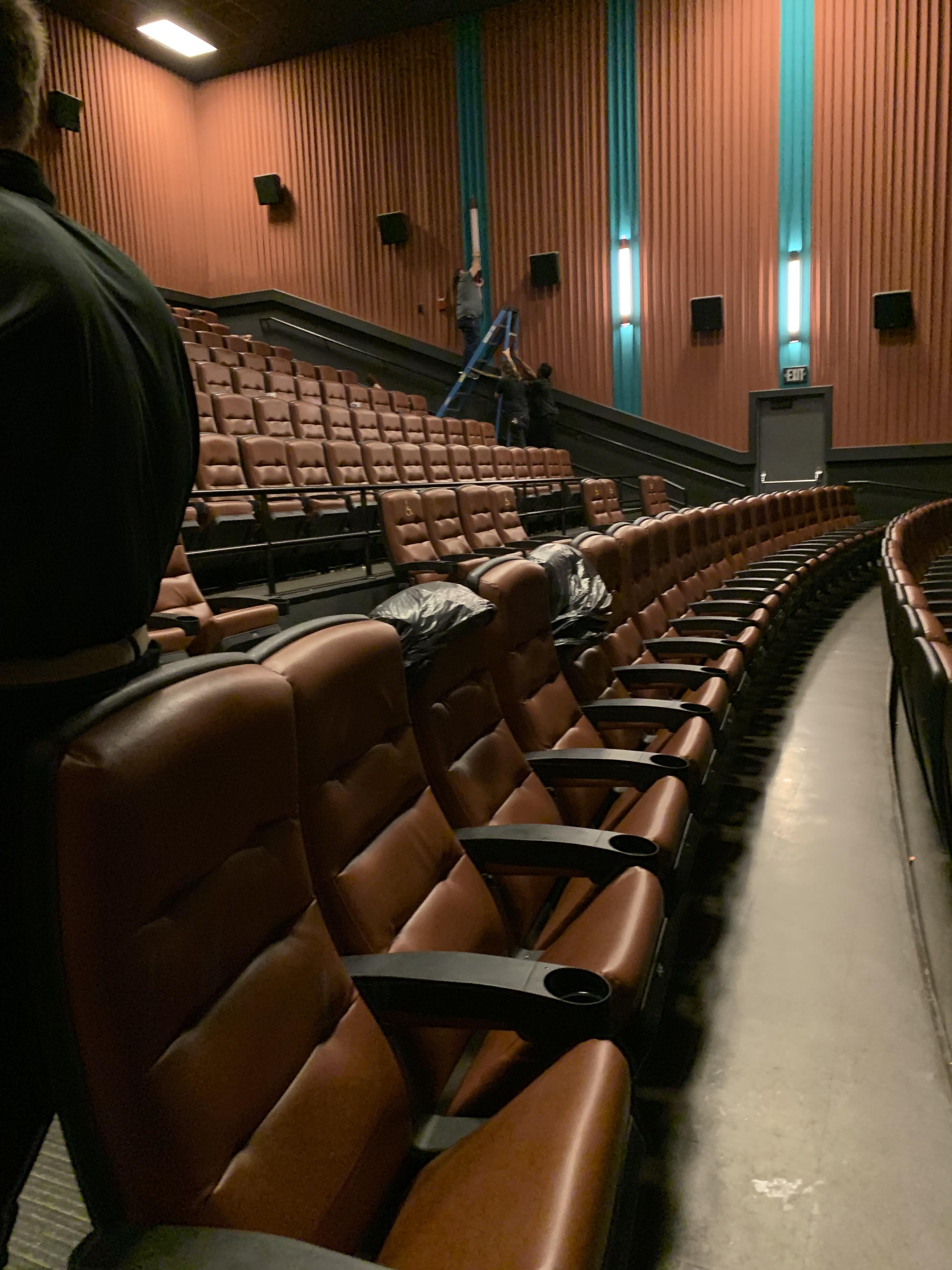 Fixing the lights in the movie theater with the ladder on the stairs