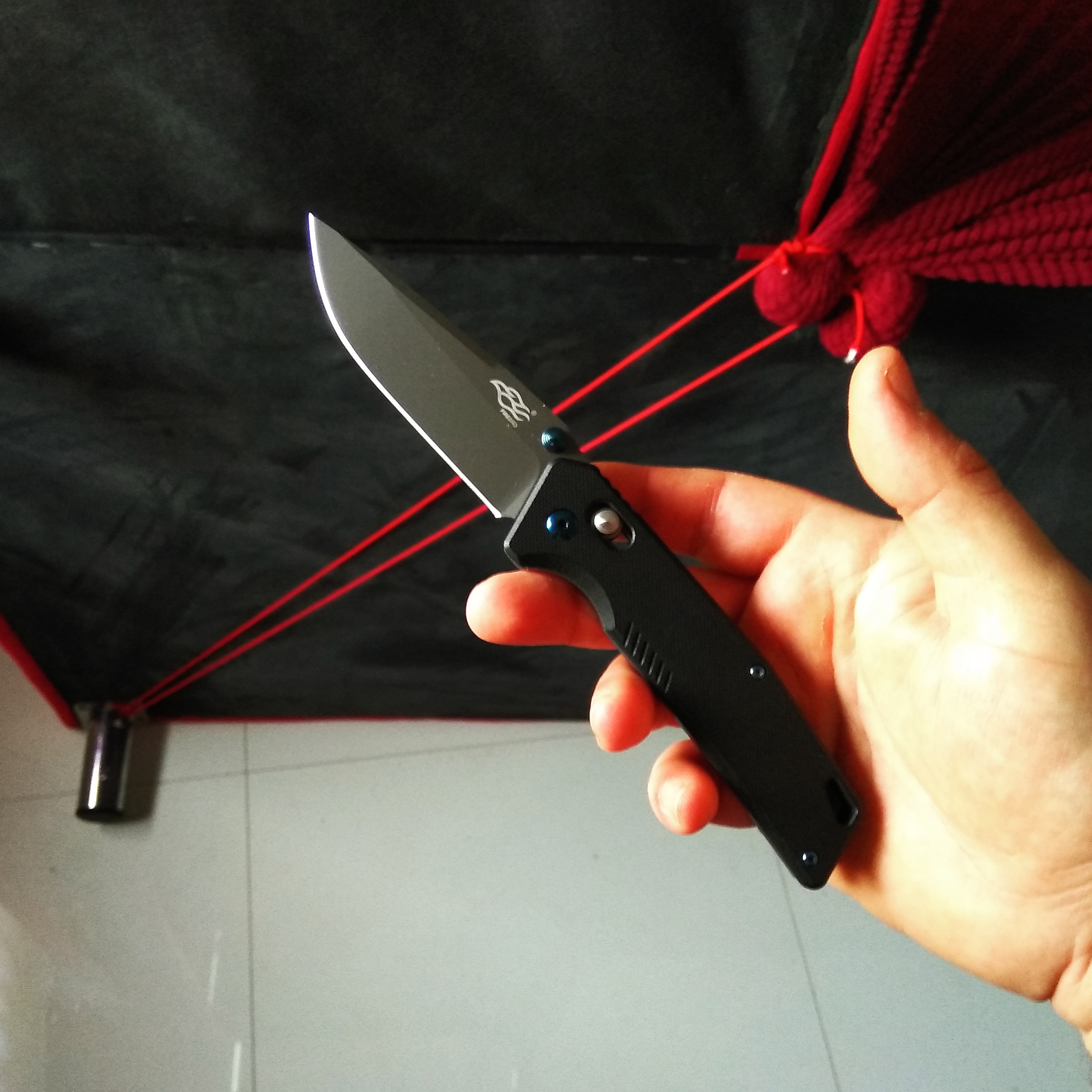 Budget EDC knife use stretching the cover of the couch using paracord