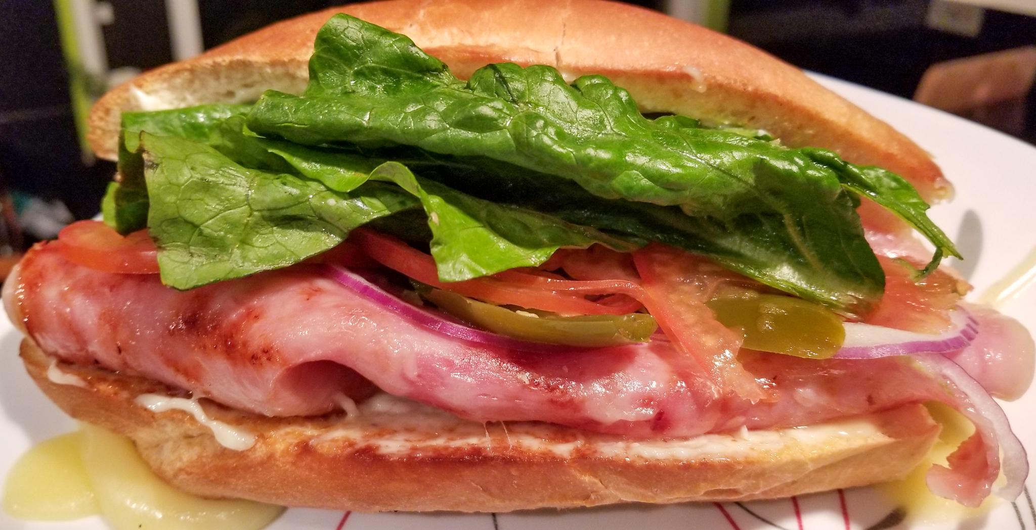 Torta with fried ham, melted jack, avocado, lettuce, tomato, onion