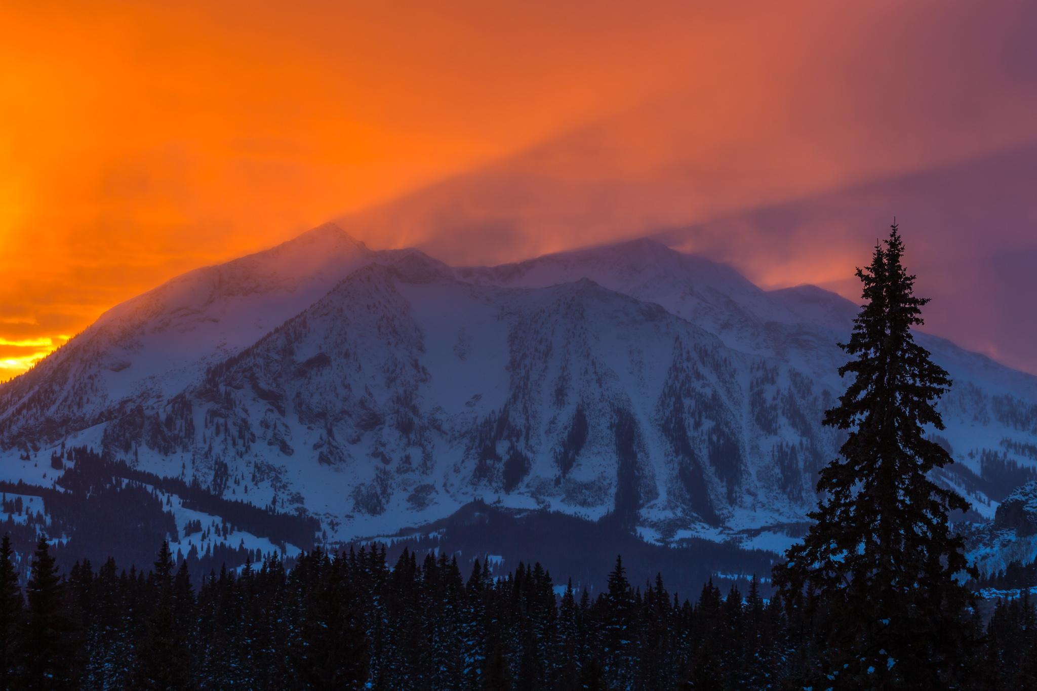 Crepuscular rays shine over a mountain during sunset. Somerset