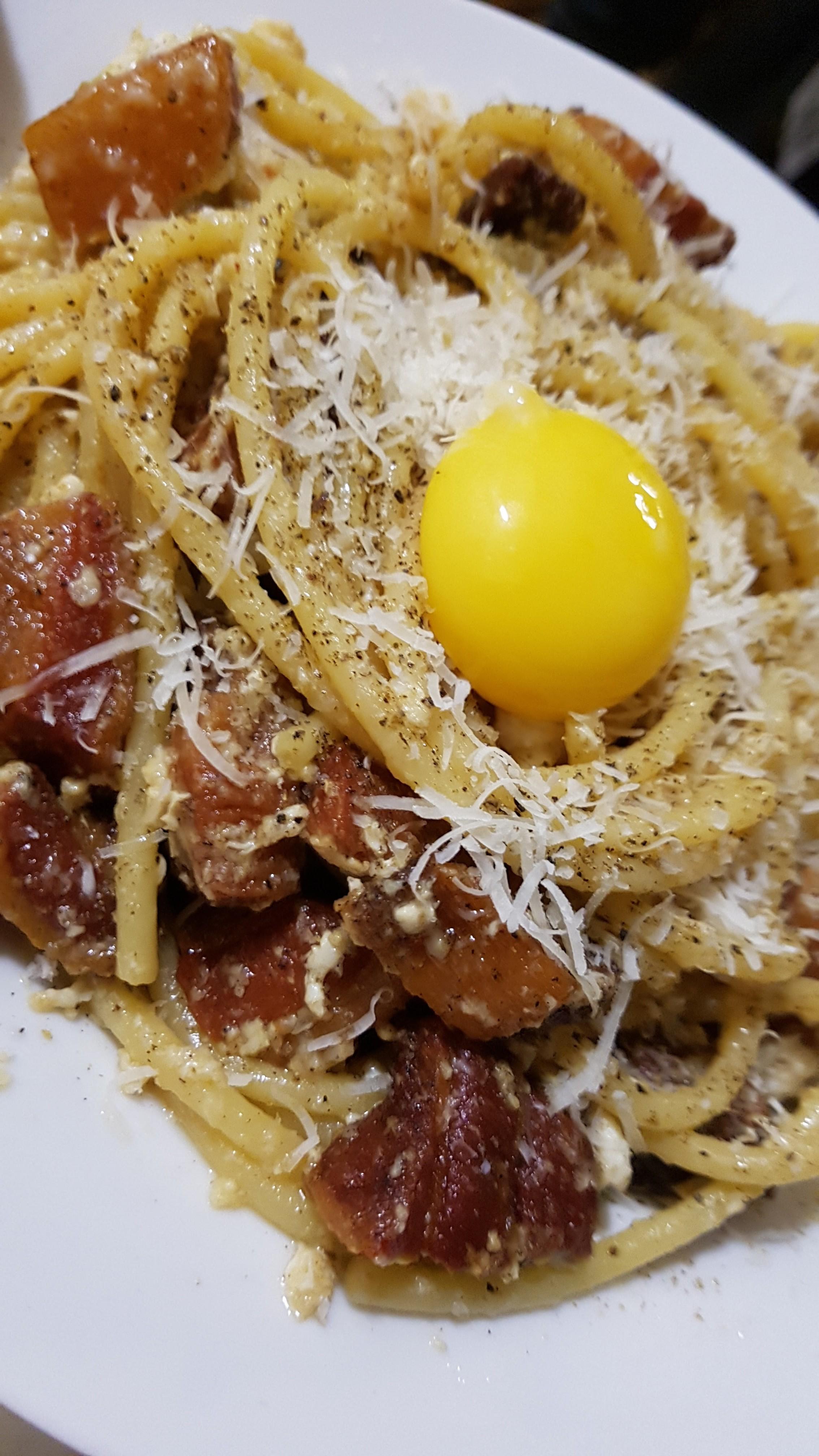 Bucatini alla Carbonara with chunks of pancetta, topped with Romano