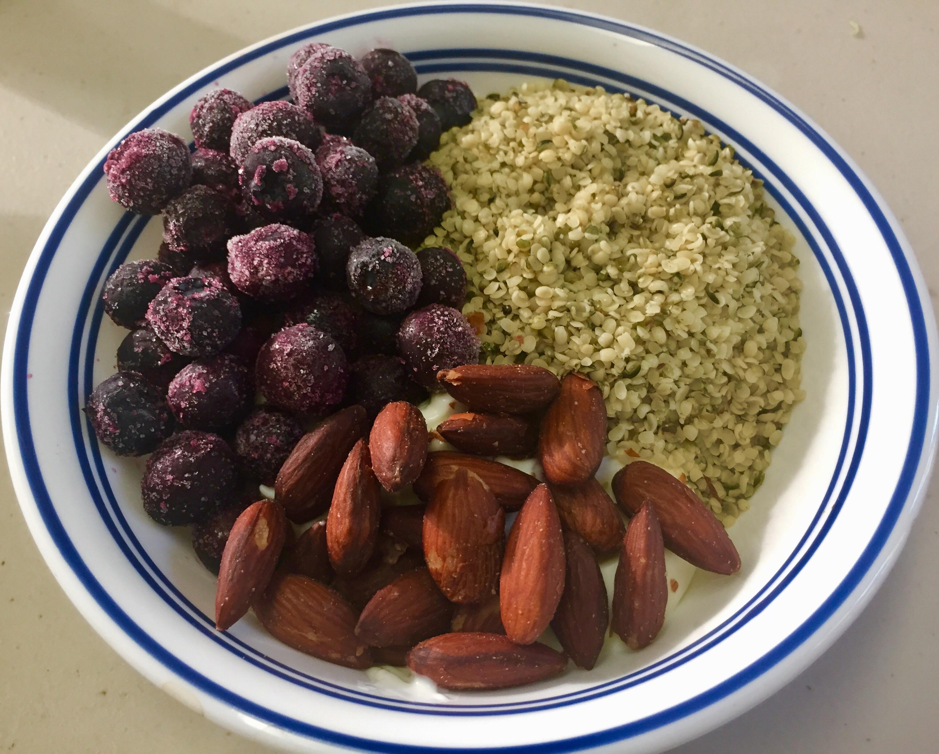 Crunchy almonds, delicate hemp seeds, & frozen blueberries over honey