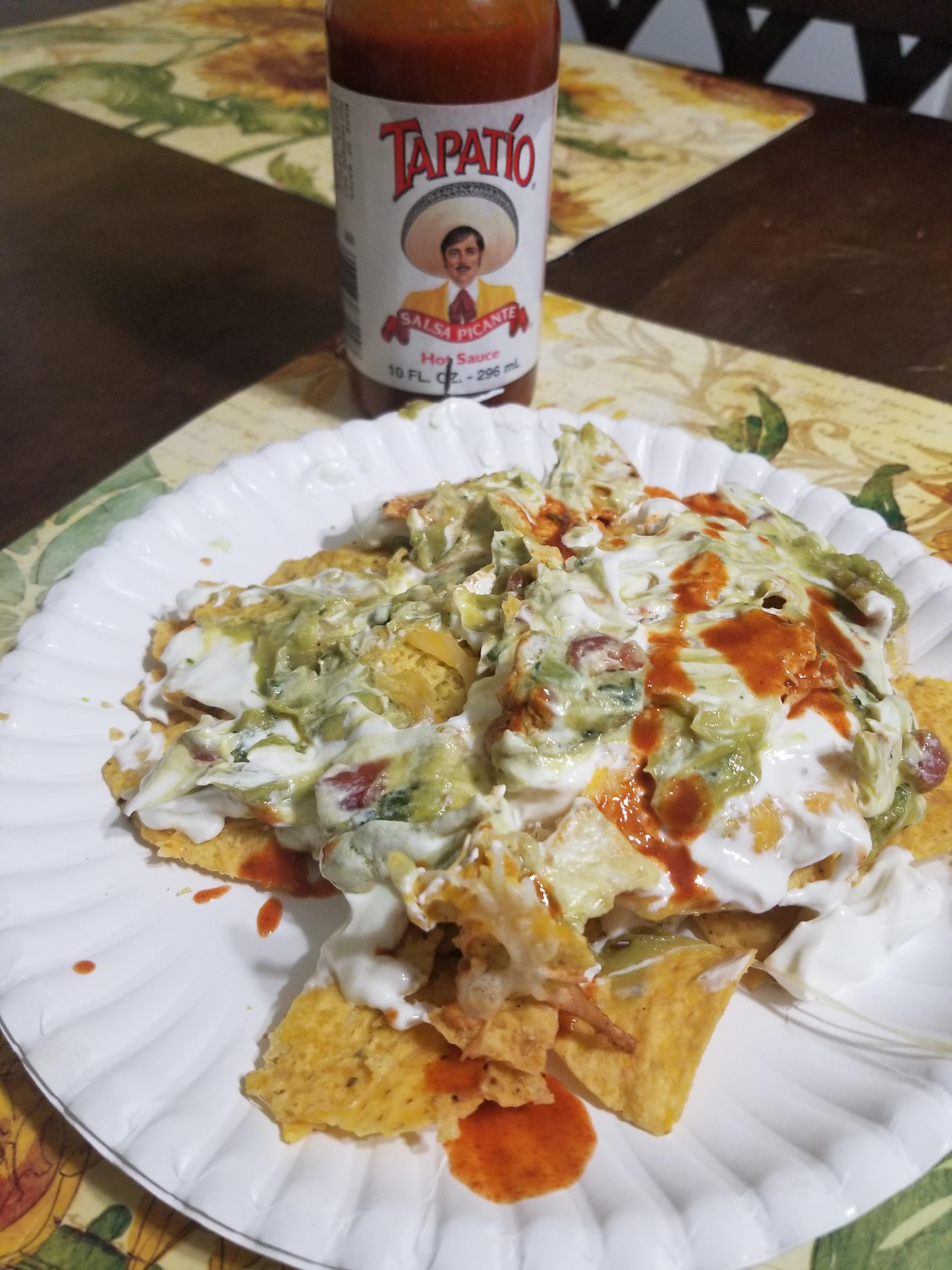 Nachos cooked in toaster oven and smothered in sour cream and guac