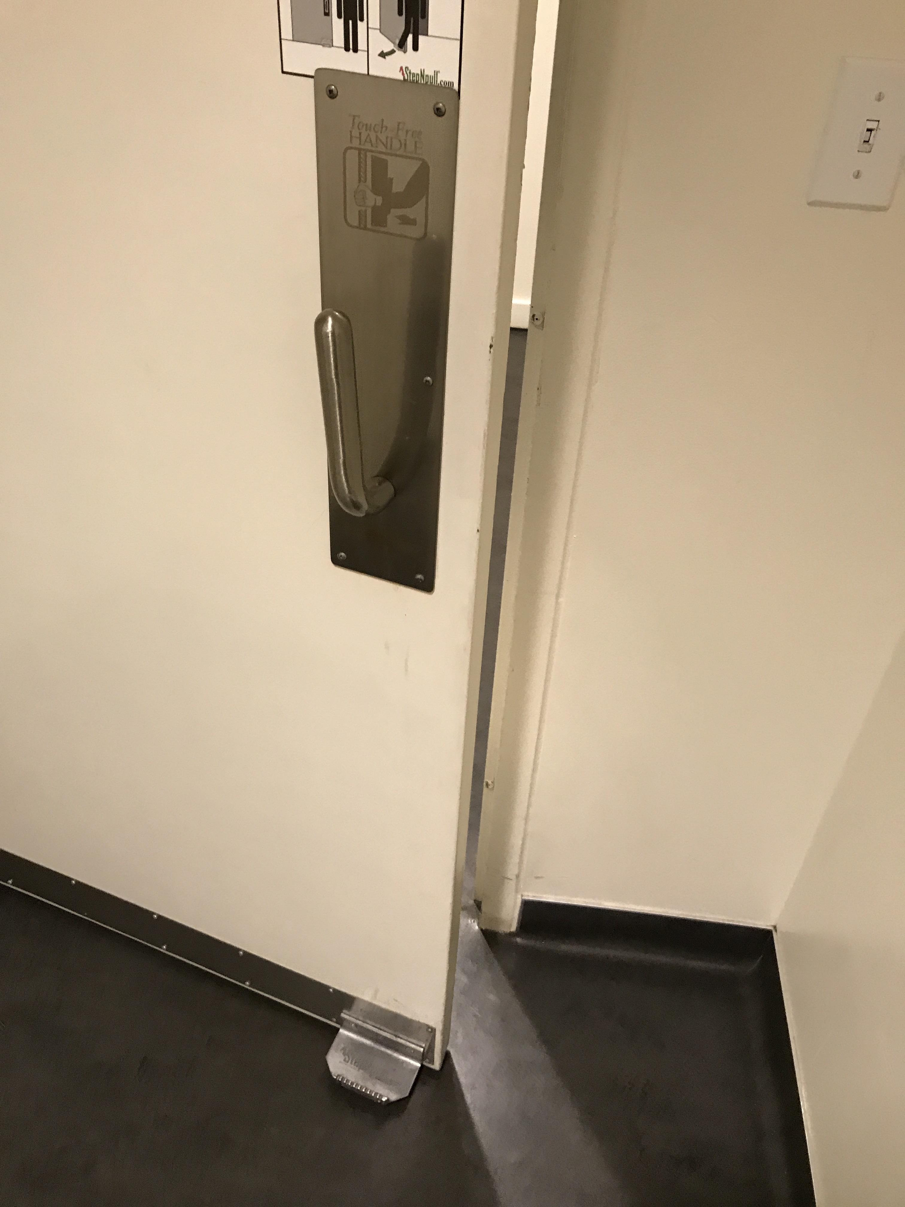 This public bathroom has a handle on the floor to limit the spread of