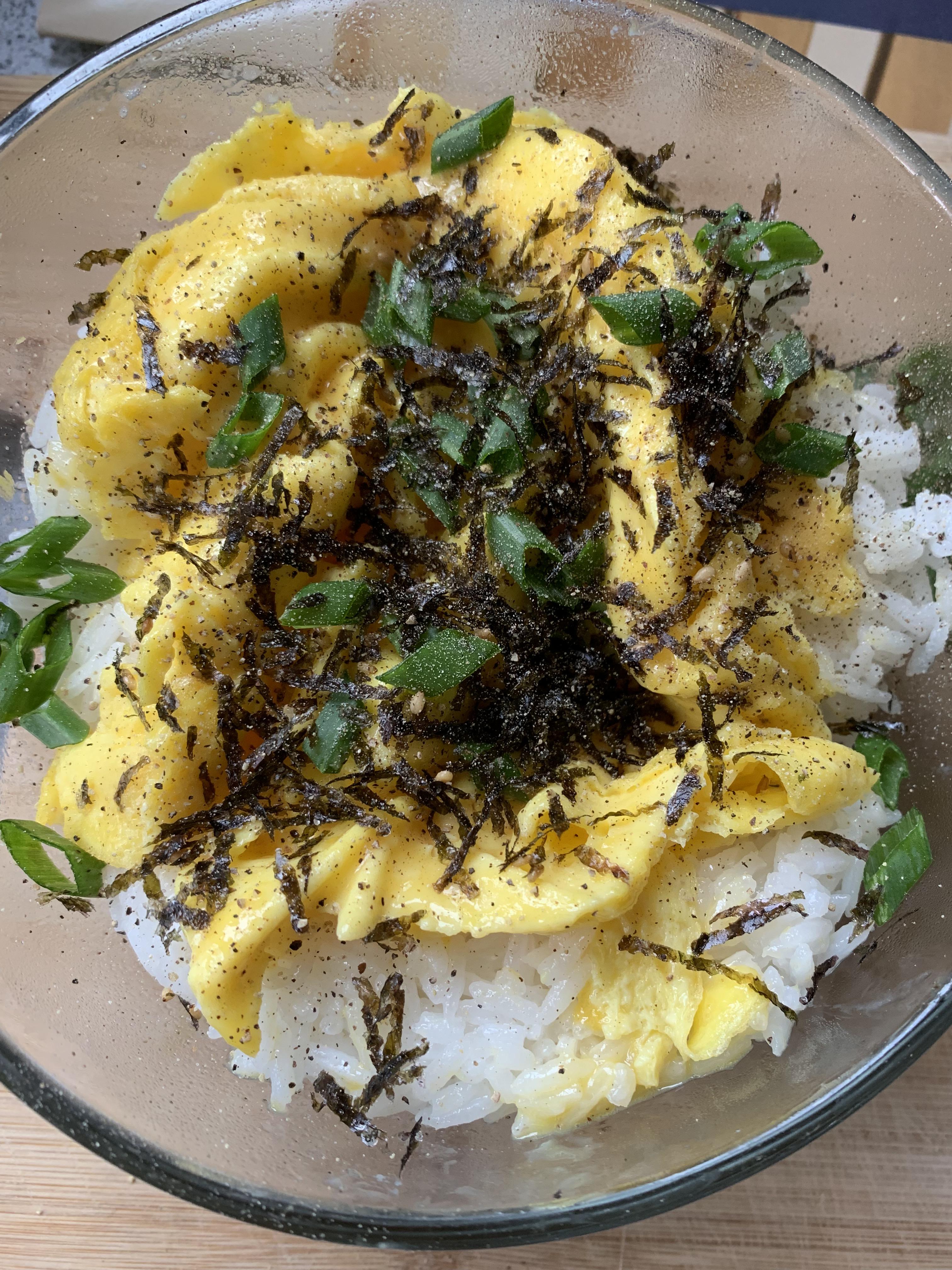 Eggs over white rice with Korean seaweed and green onions. Simple