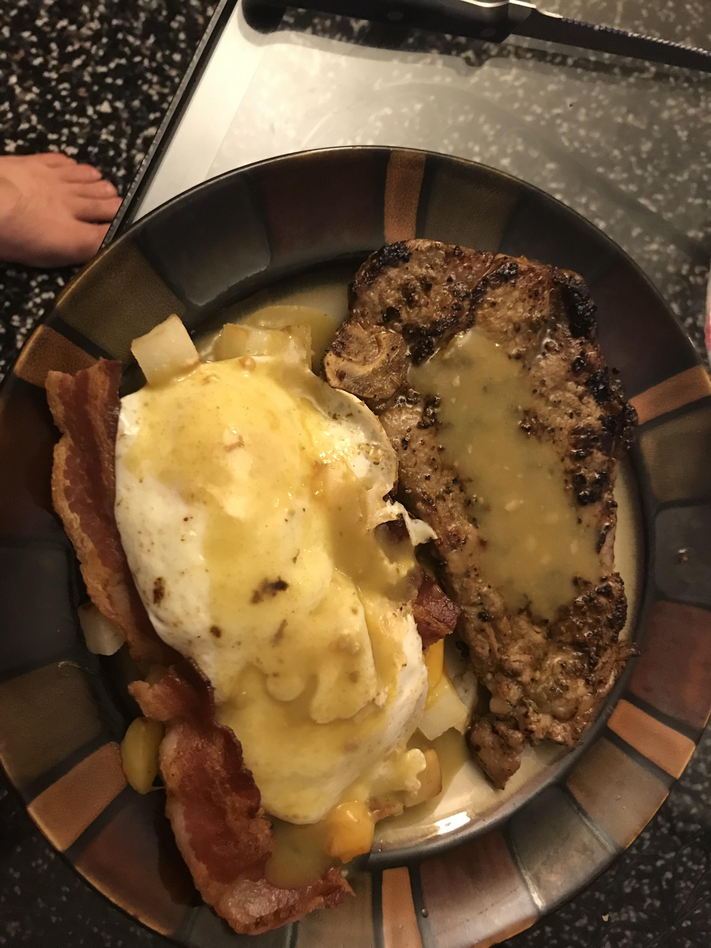 New York Strip Steak with 2 eggs over easy on top of hashbrowns and