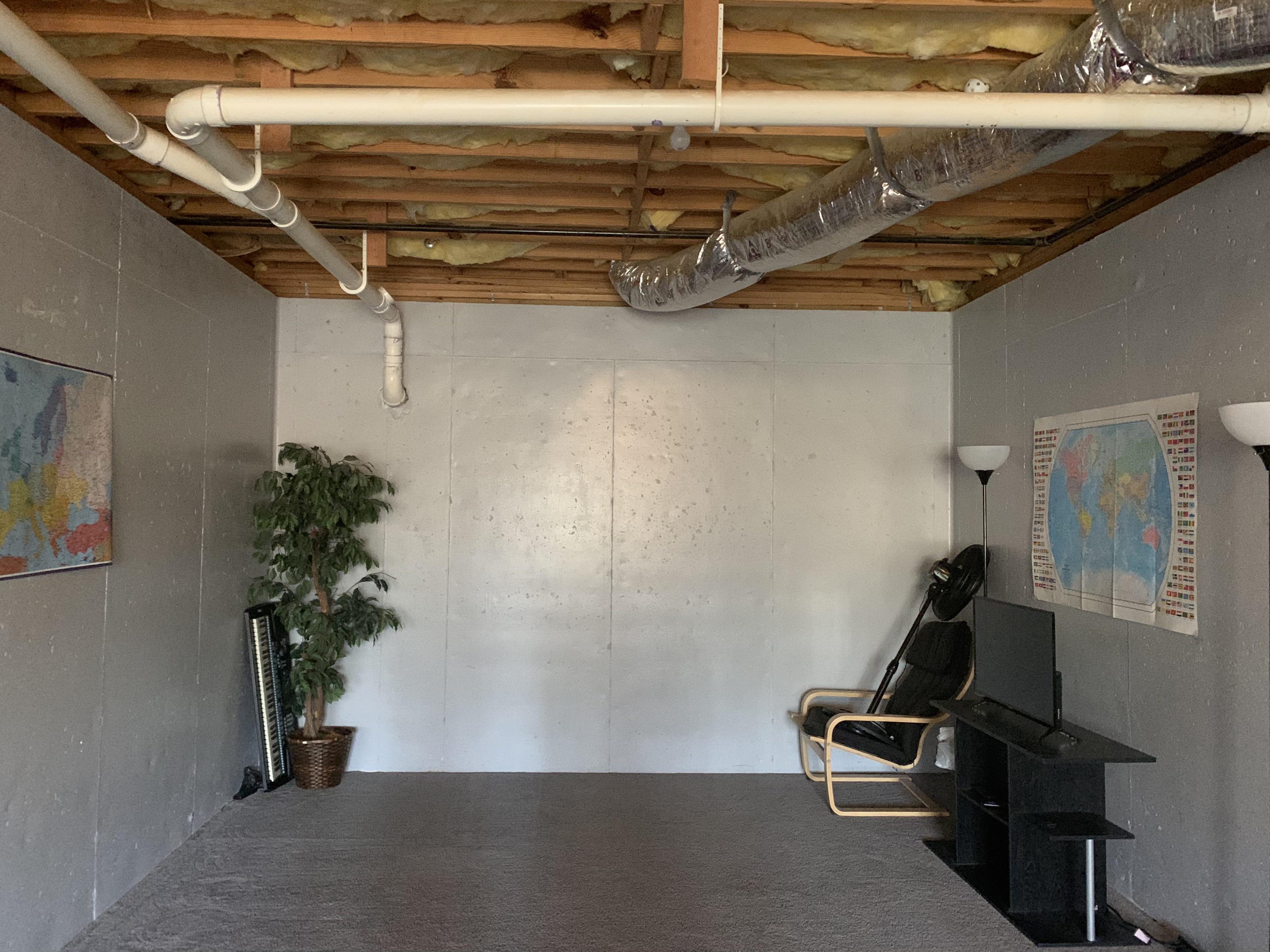 What can I do to make this concrete basement wall look cozier? I can’t