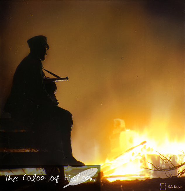 A Finnish Soldier sitting by a Bonfire during the Continuation War r