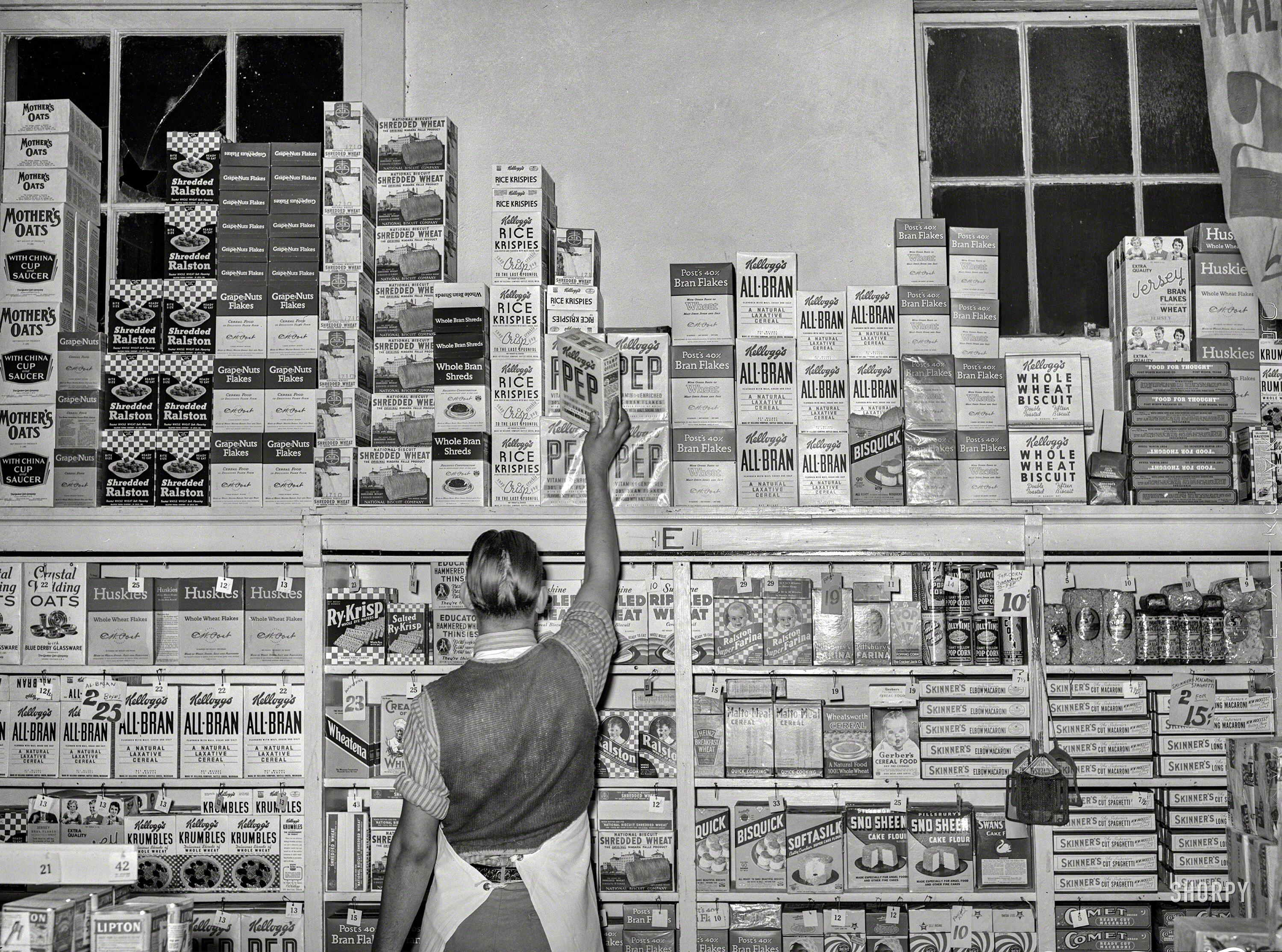 [1939] stocking shelves at a grocery store in San Angelo, Texas r