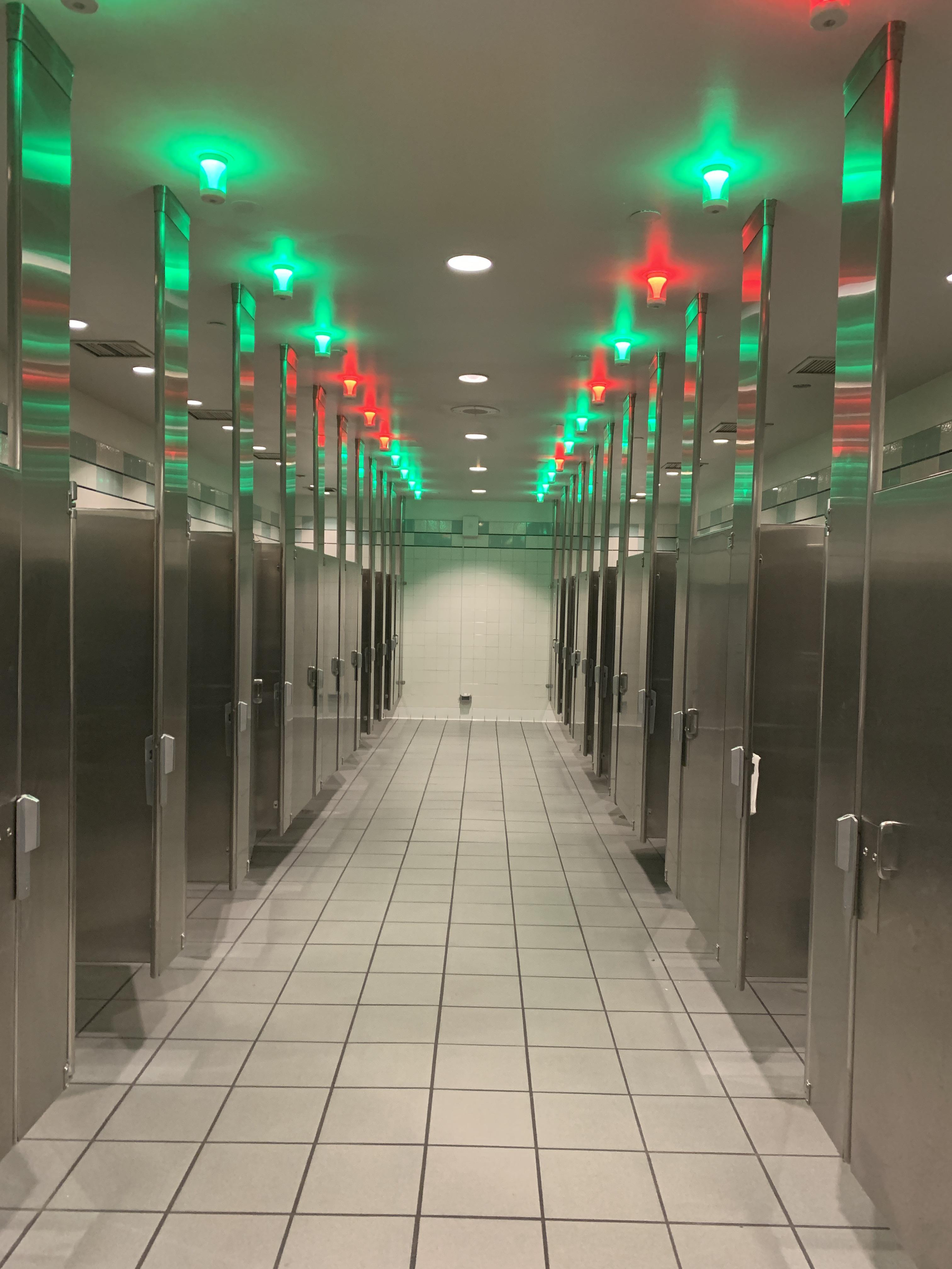 This airport bathroom has lights to show you which stalls are free.
