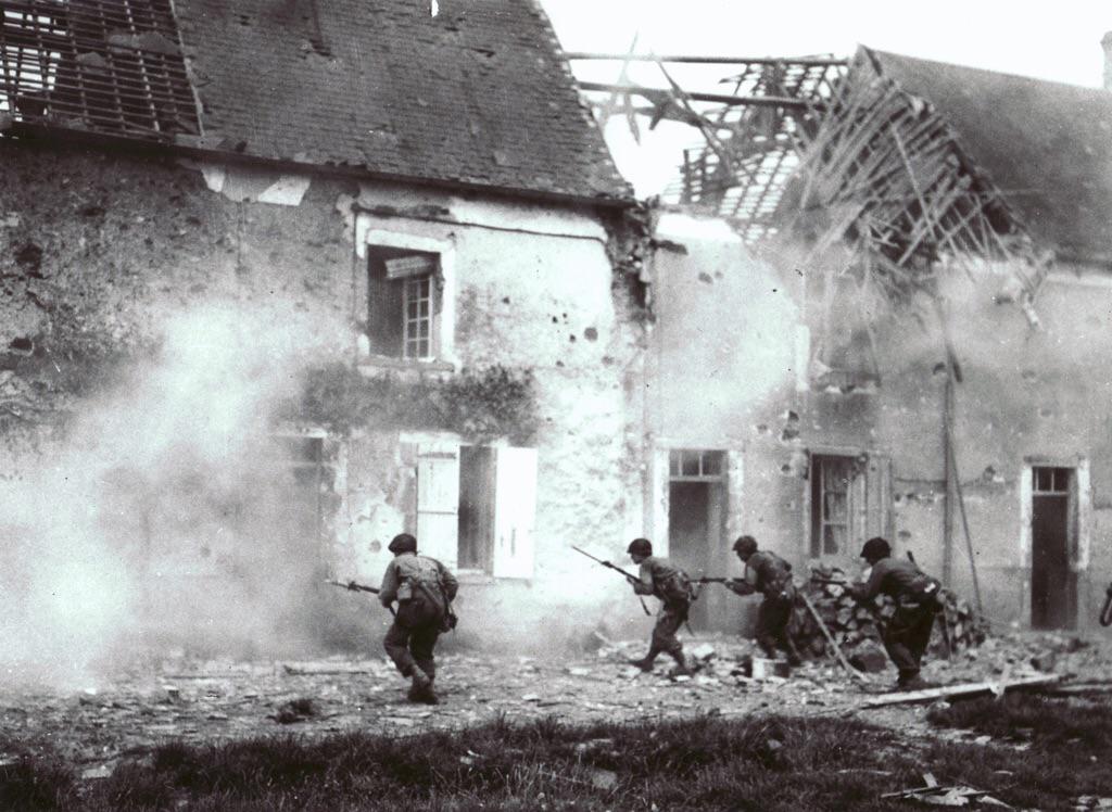 GIs rush a burning house in Sainteny, Normandy, July 11, 1944. r