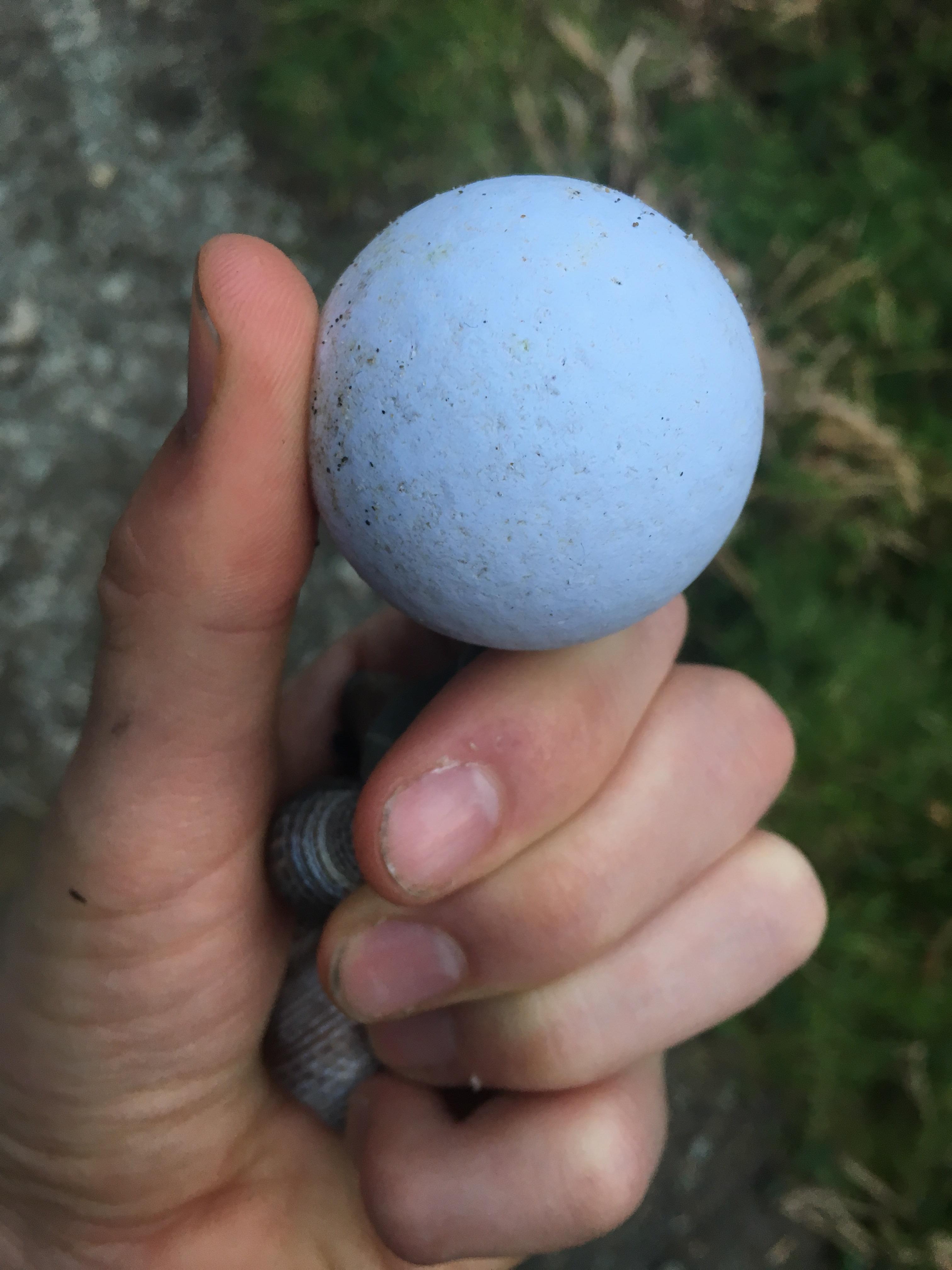 This golf ball that has been made almost entirely smooth by the ocean