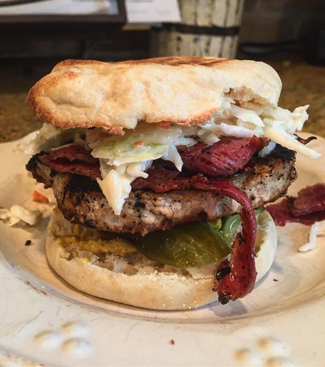 Homemade turkey burger with coleslaw, pastrami, pickle and spicy