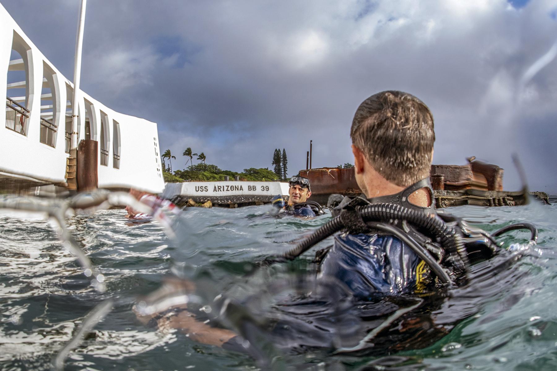 Navy divers conduct diving operations on the USS Arizona Memorial at