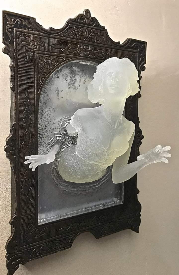 Sculpture of a Victorian ghost emerging from an antique mirror cast in