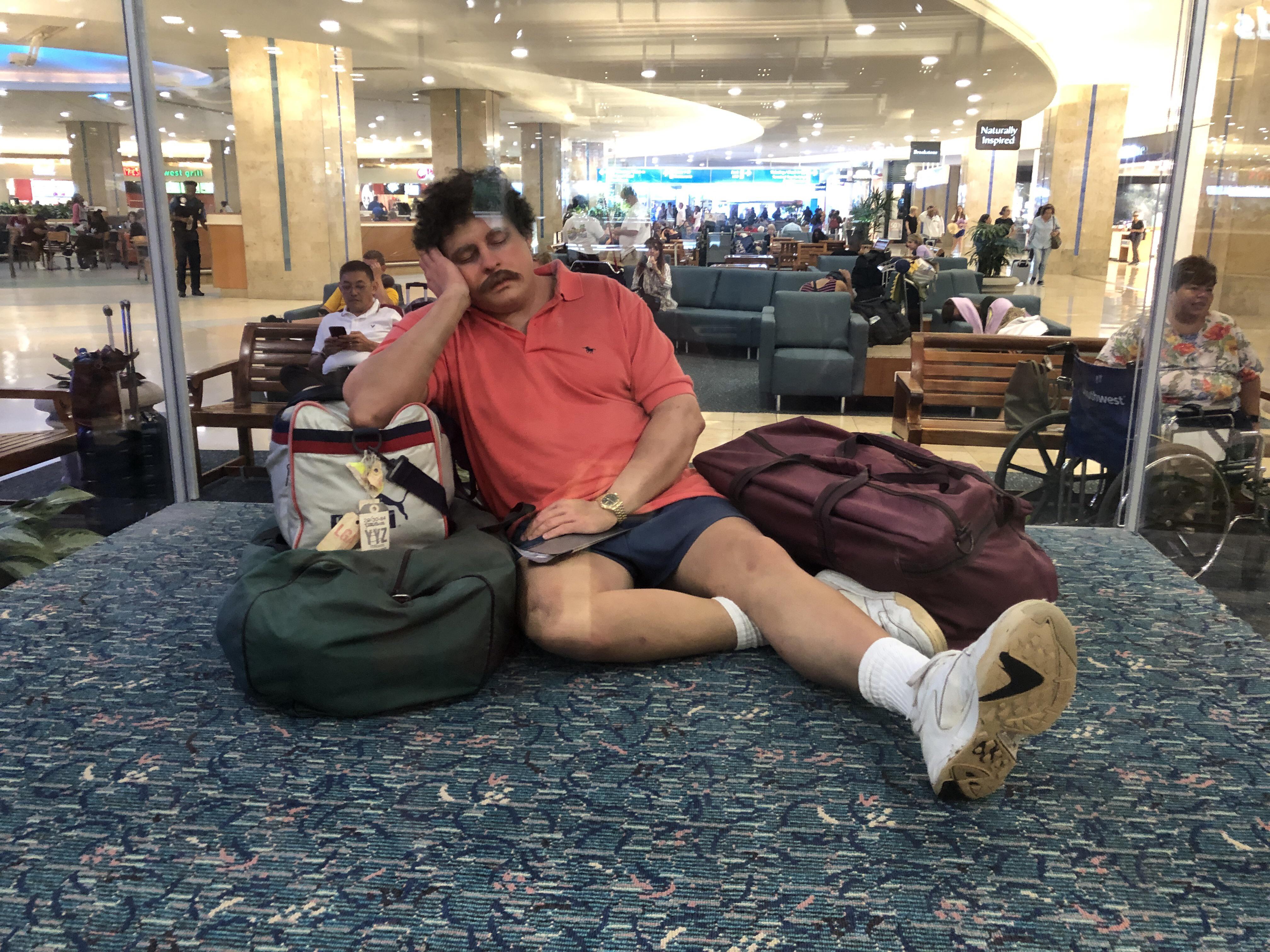 This statue of a exhausted traveler in Orlando International Airport