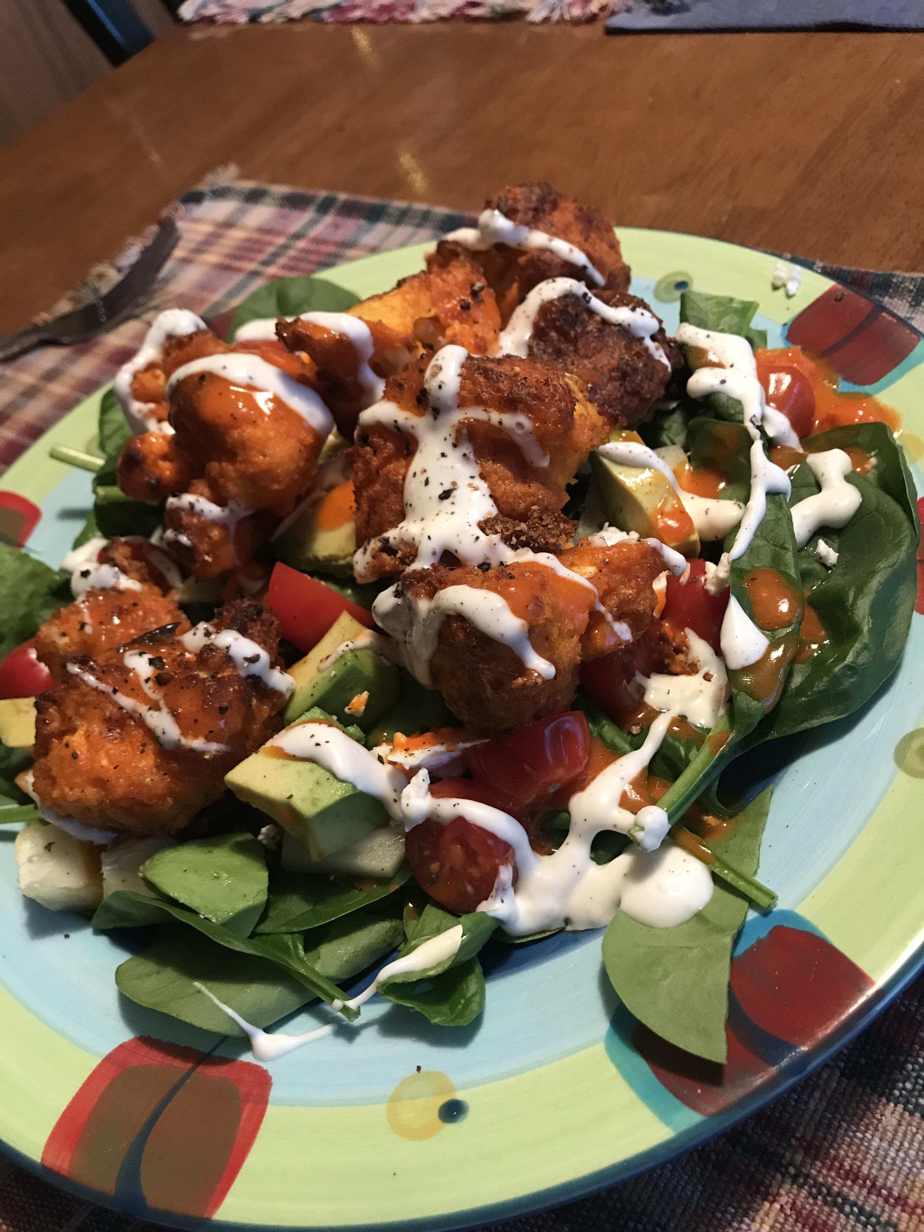 Buffalo cauliflower “ wings “ made in an air fryer over salad with blue cheese dressing r