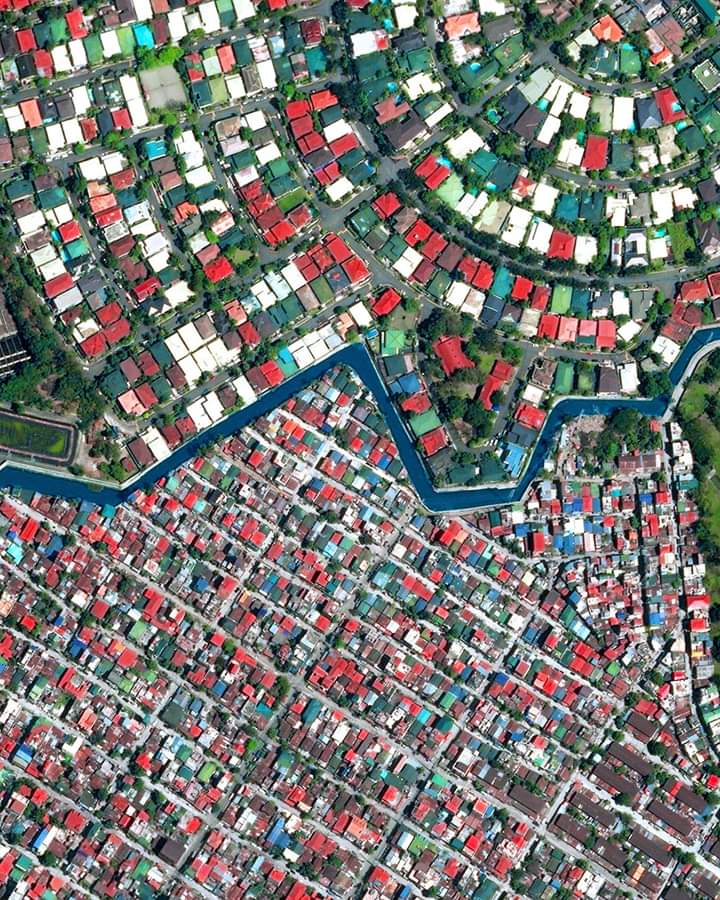A river separating the well off and poor slums of Manila, Philippines