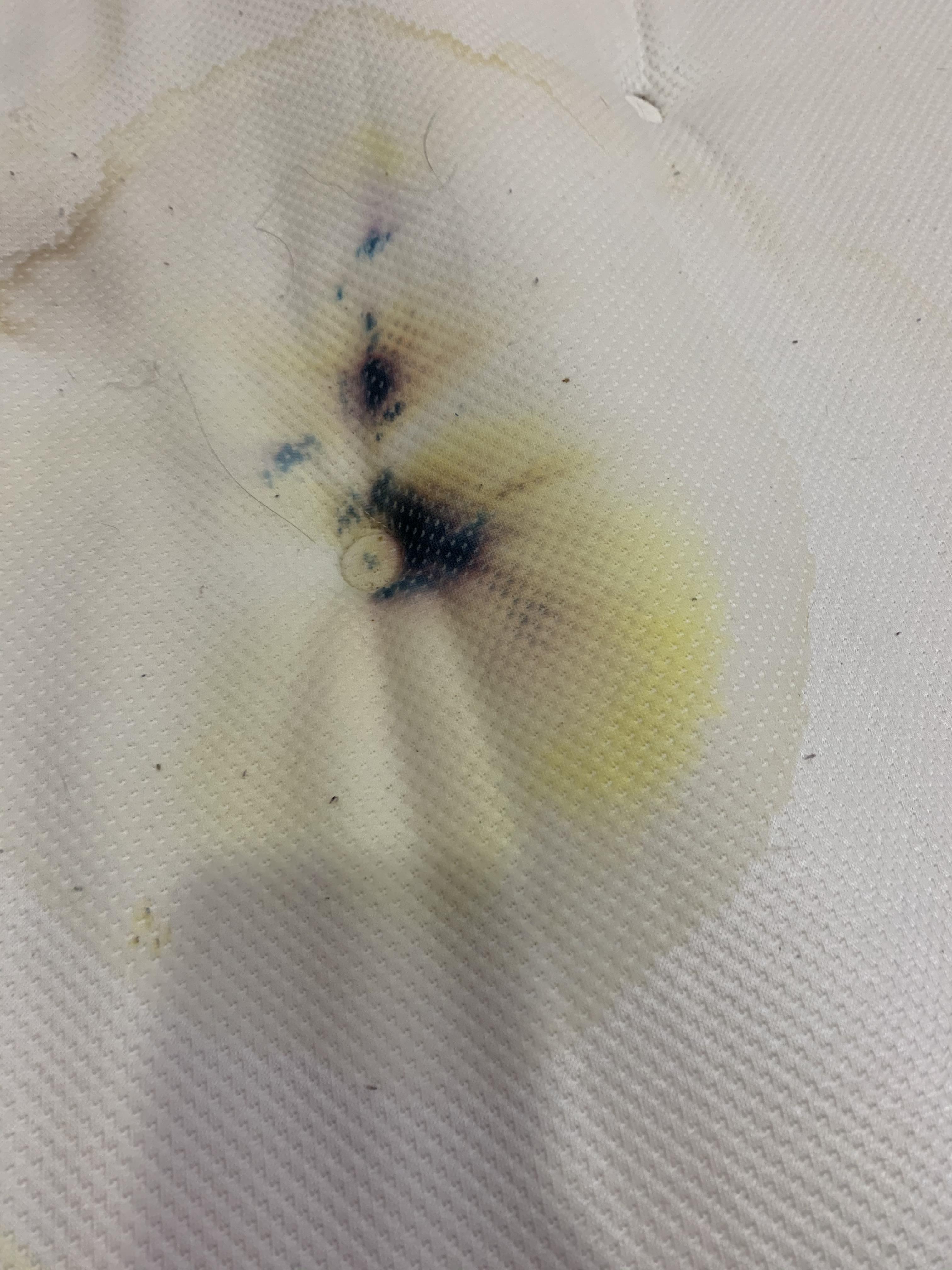 Yellow stain on the bed that turned various colors when sprayed with