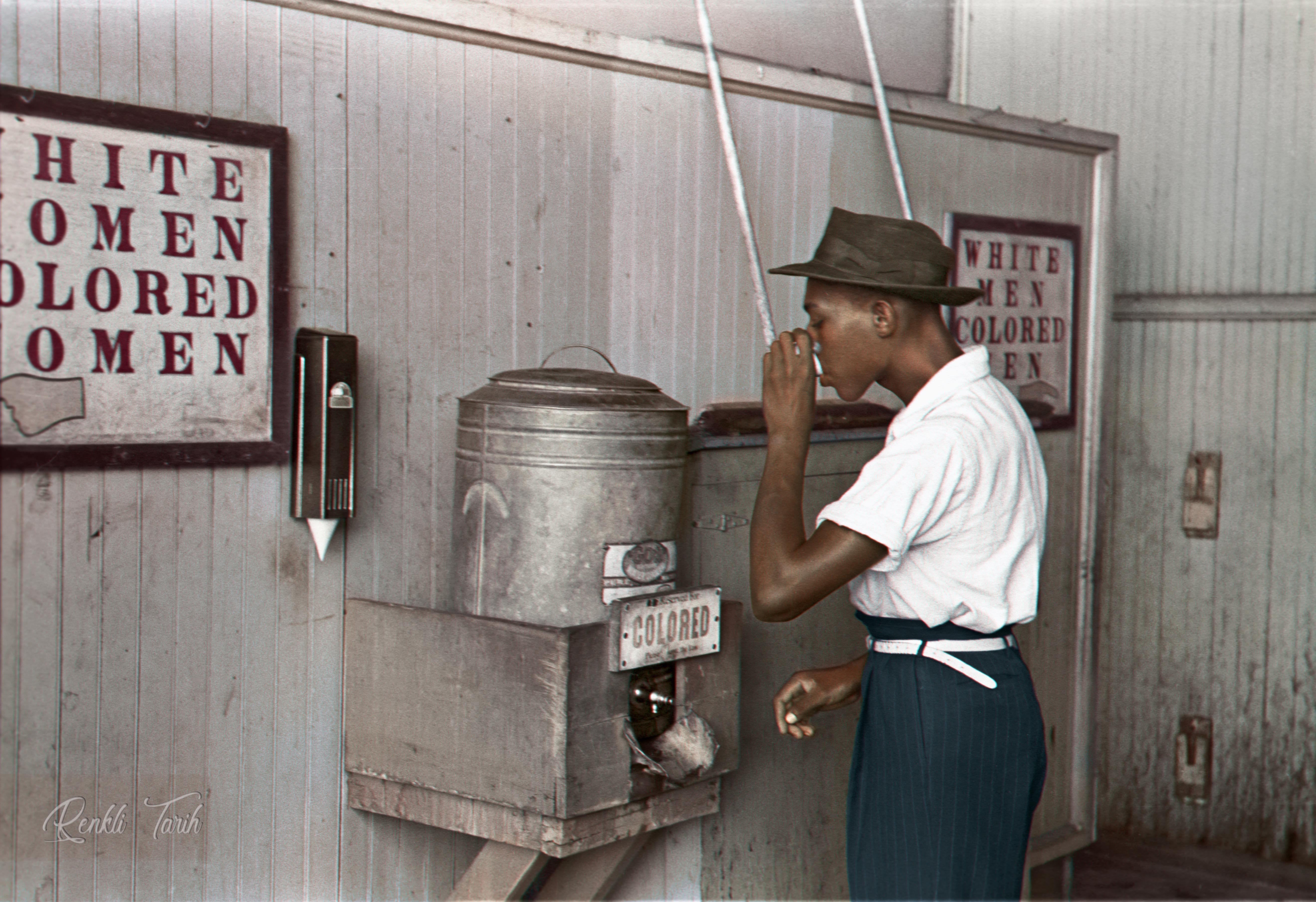 An AfricanAmerican man at a segregated restroom and drinking fountain