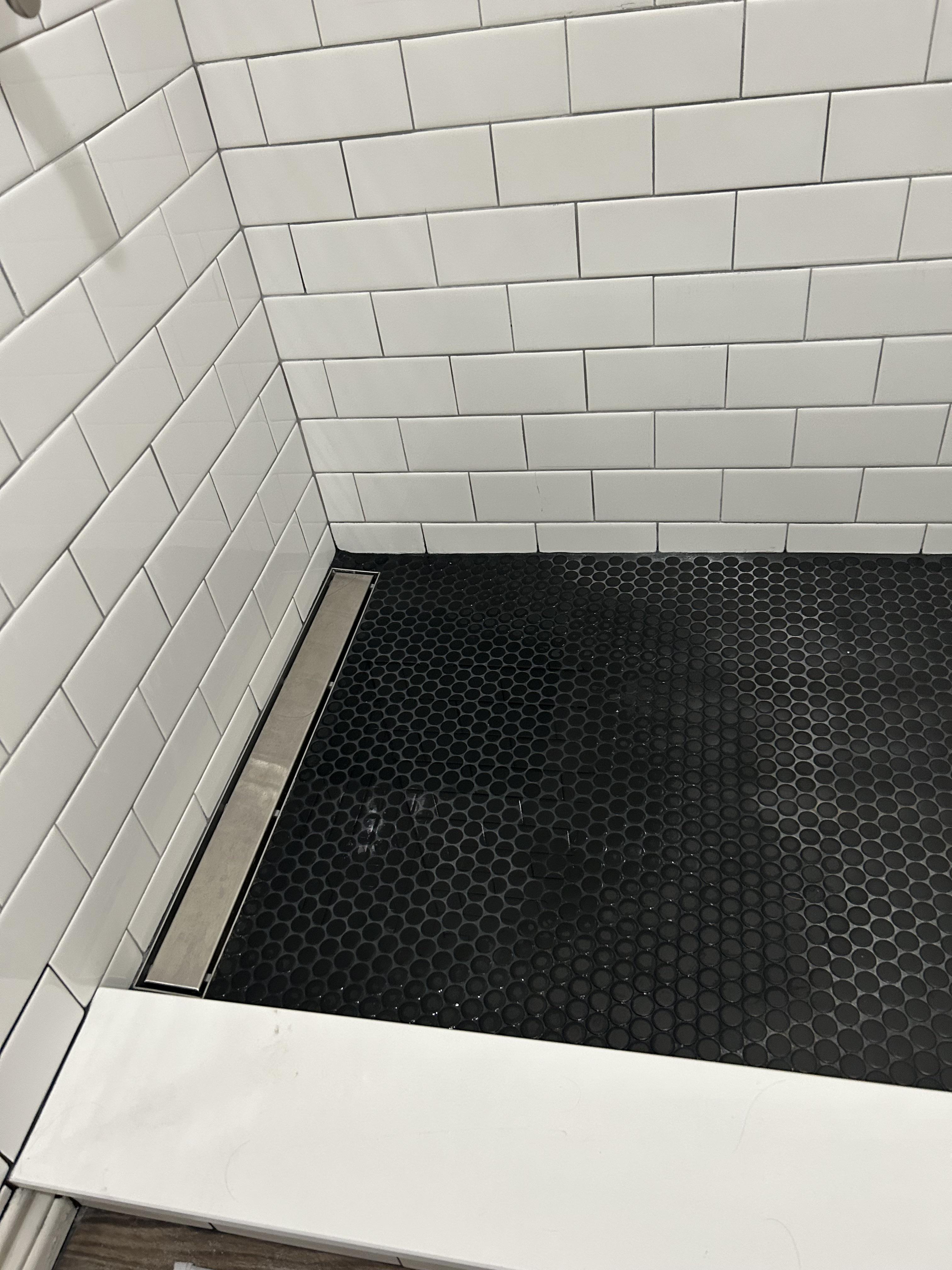 My new shower doesn’t drain all the way, leaving a pool of water on one