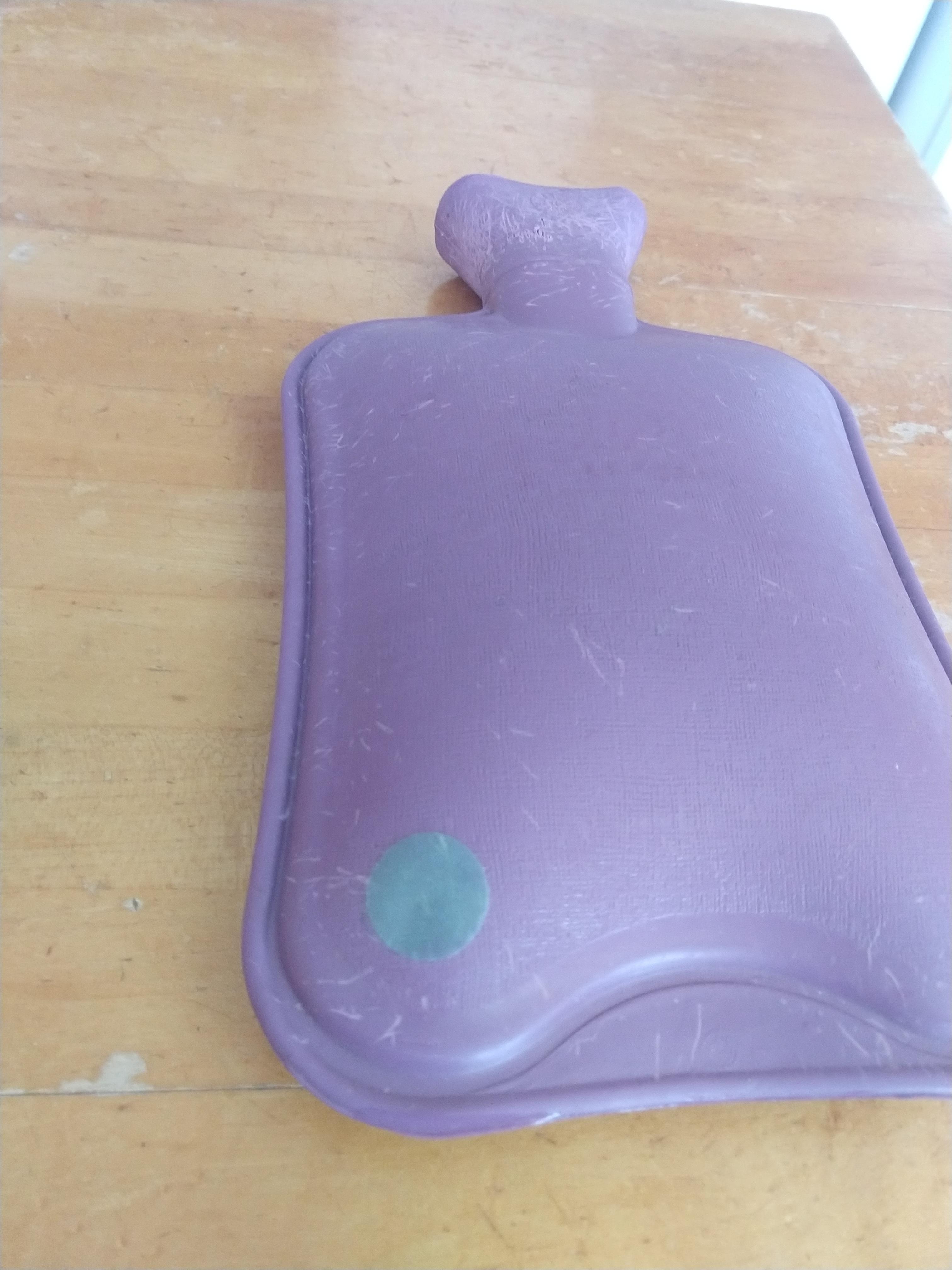 My puppy chewed a hole in the hot water bottle; I fixed it with a bicycle inner tube scab