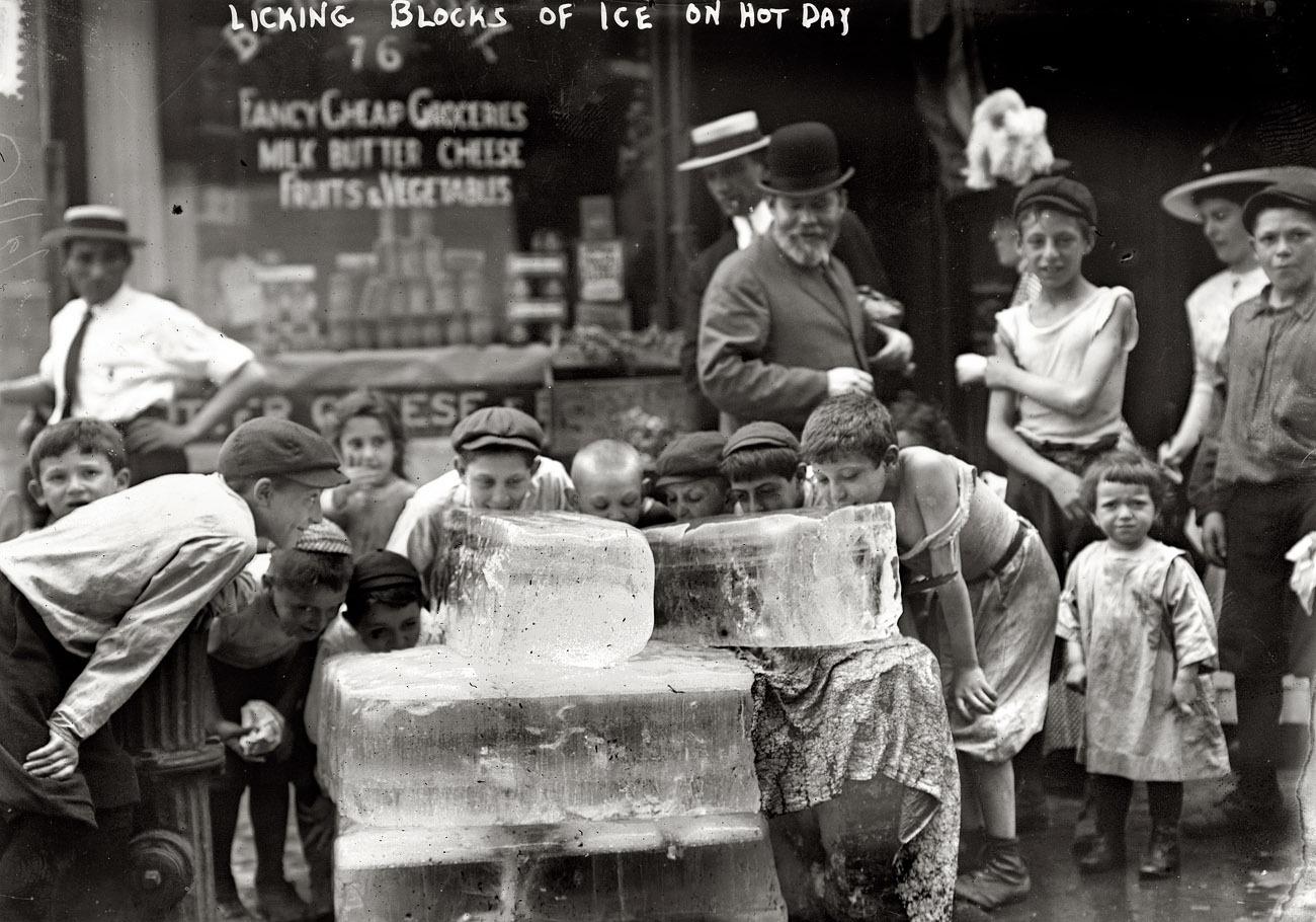 Children licking blocks of ice during a heat wave in New York City
