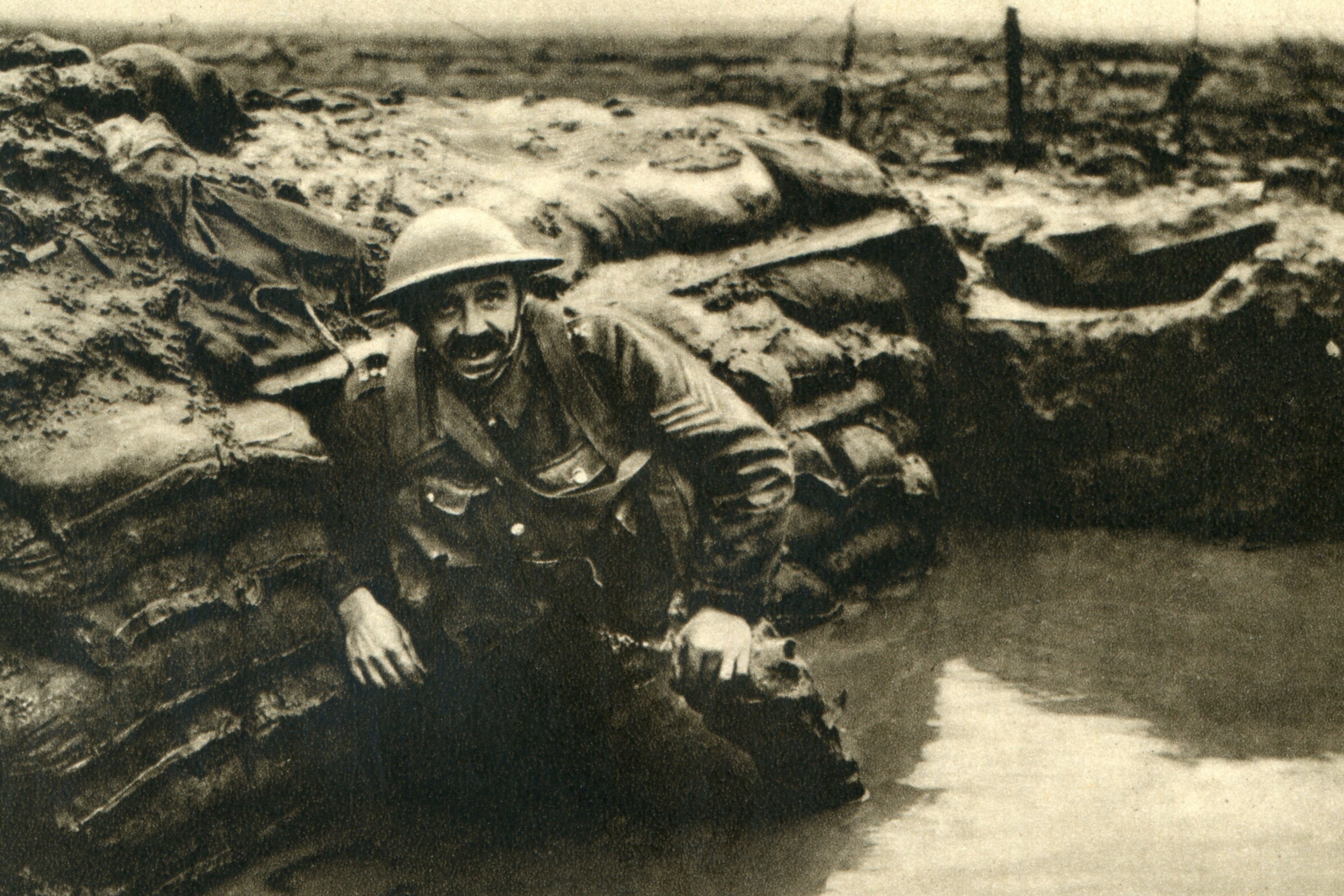 A British soldier rests in a waterlogged trench in Belgium, during the