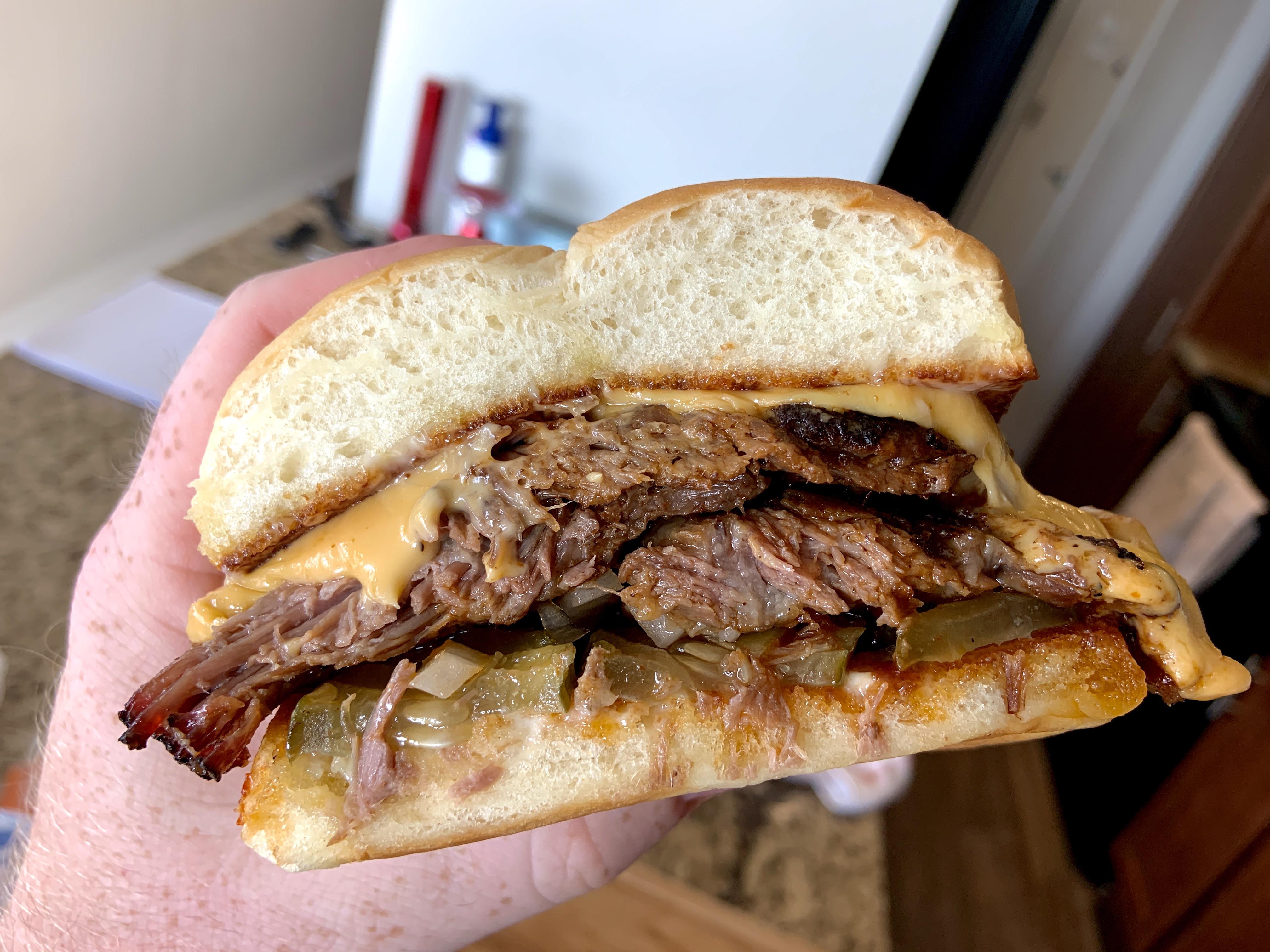 Leftover fatty brisket sandwich with cheese, onions and spicy pickles on Hawaiian rolls! r