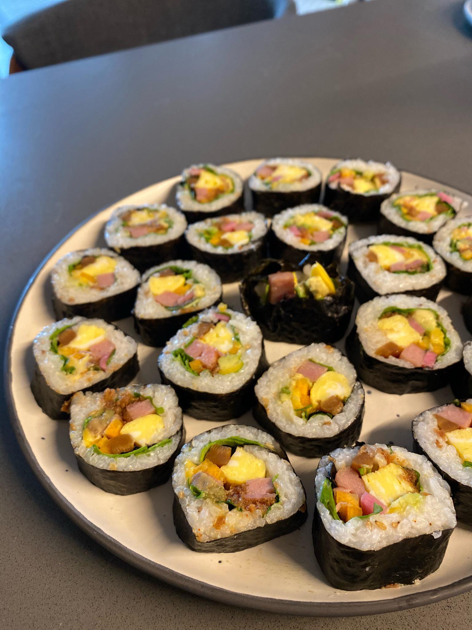 Kimbap with spam, egg, cheese, carrot, burdock, pickled purple daikon, avocado, arugula, and a