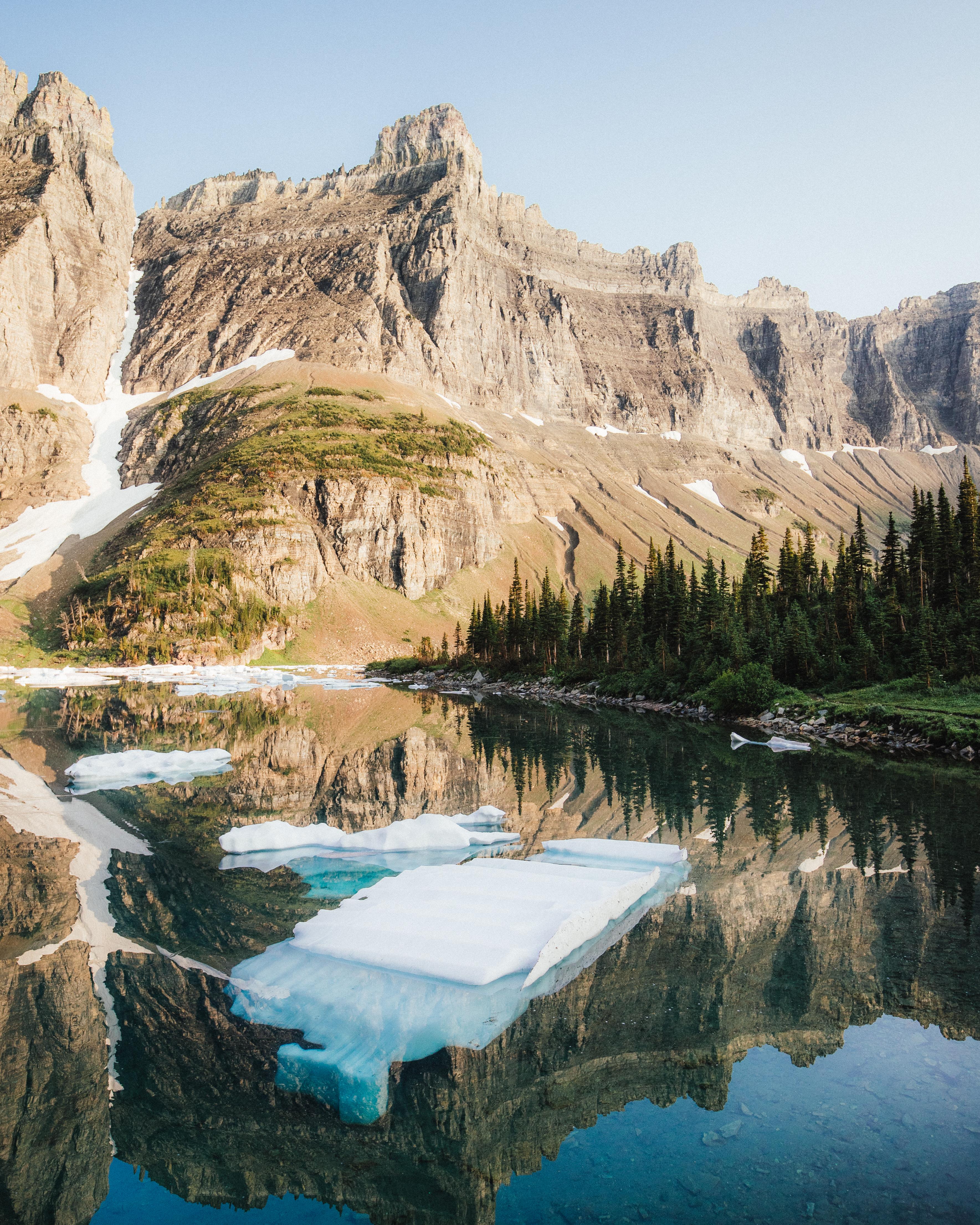 Icebergs in a lake surrounded by giant mountains. Iceberg Lake, Glacier