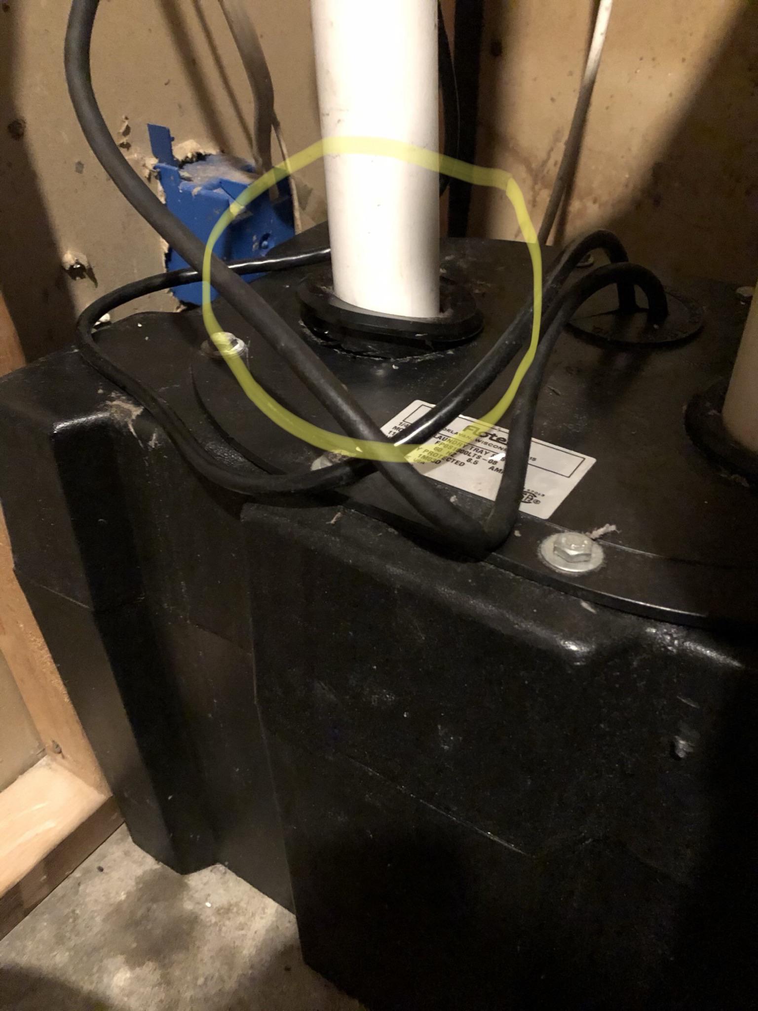 Basement sump pump leaking from top; appears to be cracked/open where