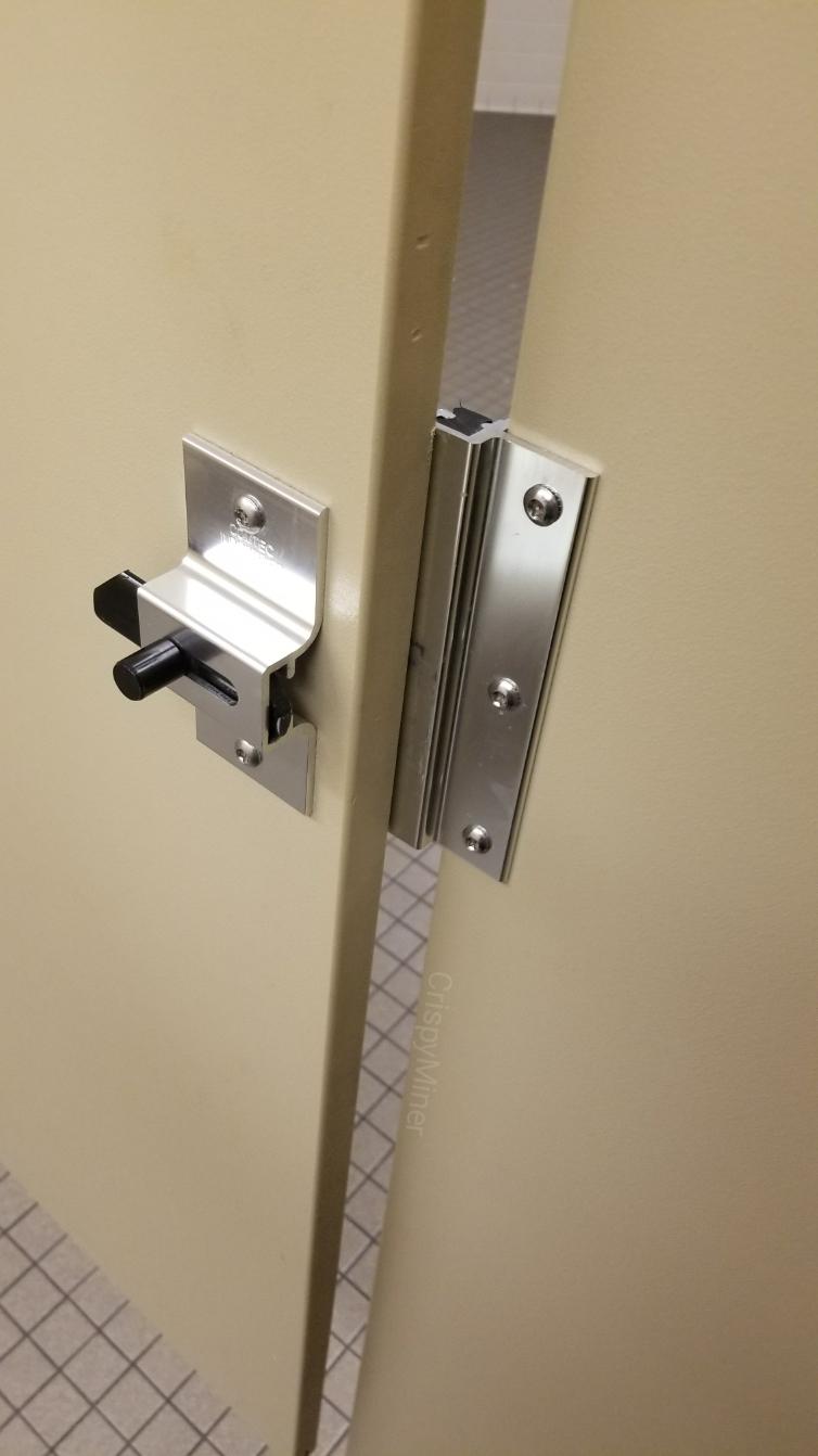 The bathroom stall door is behind the lock, making it unable to lock it