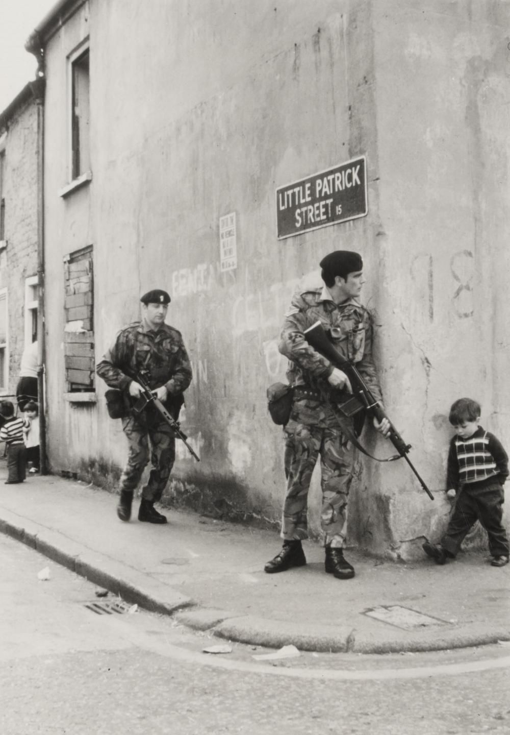 A little boy turns a corner in Belfast, Northern Ireland, 1970s. r