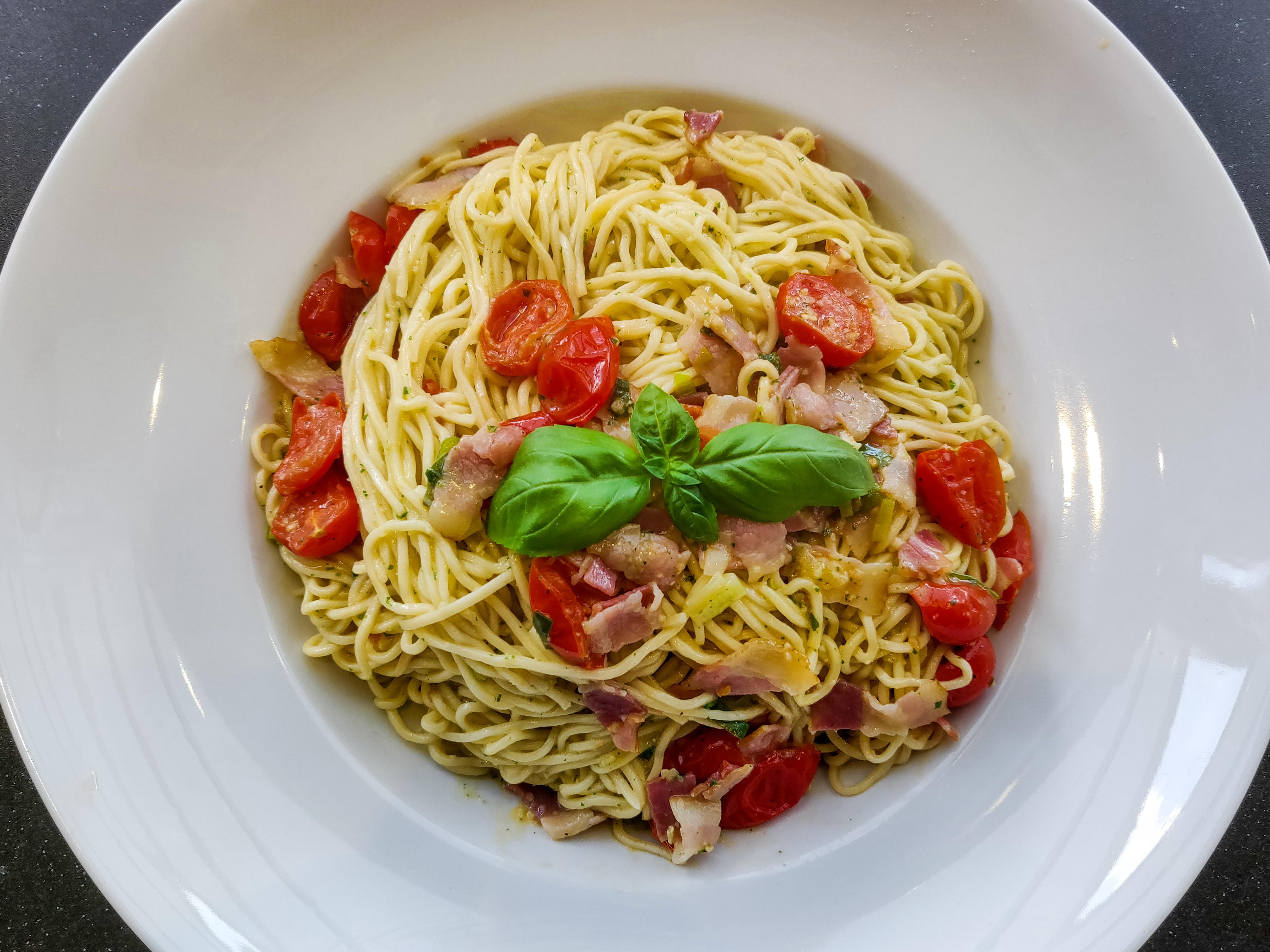 Spaghetti with pesto alla genovese with bacon and cherry tomatoes (own