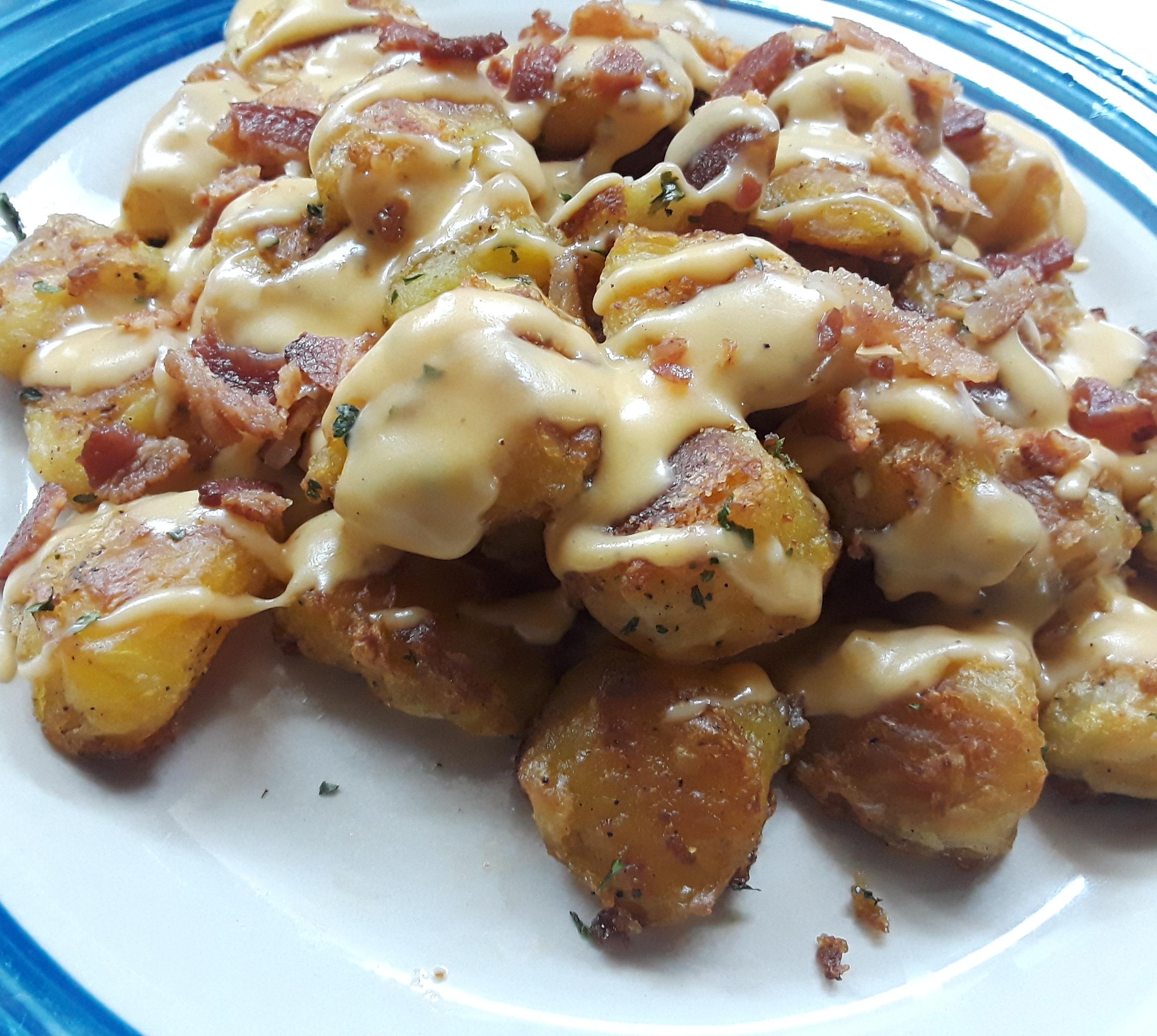 Kenji Crispy roast potatoes with cheddar cheese sauce and bacon. r