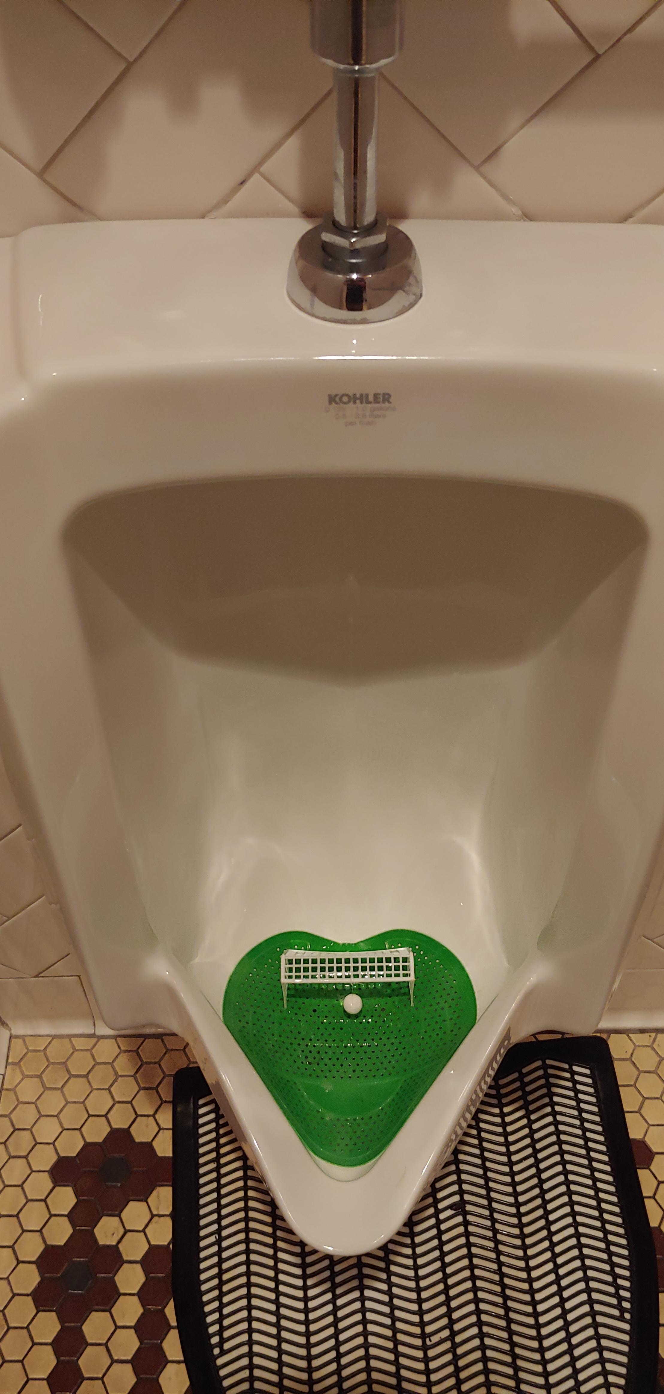 Urinal with a soccer net and ball in it r/mildlyinteresting