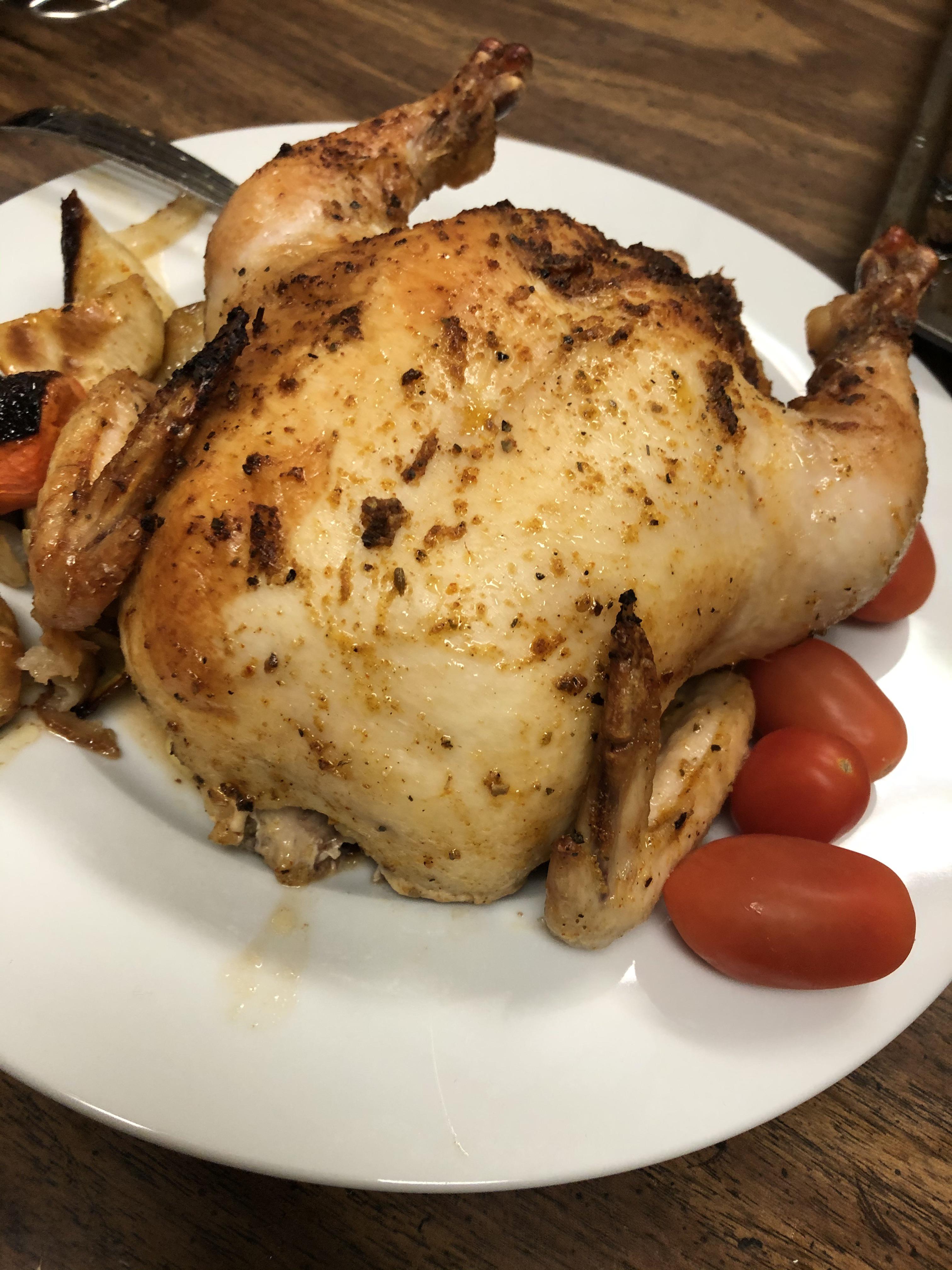 Cornish game hen with roasted vegetables and cherry tomatoes. r