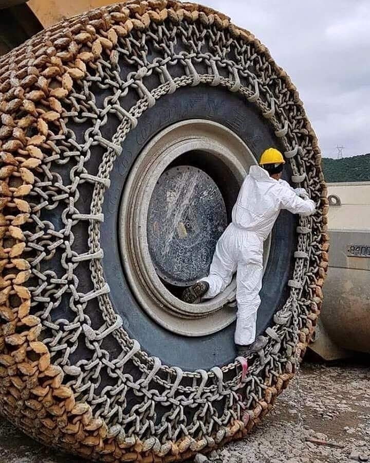 Cinching the Absolute Unit tire chains on a mine endloader absoluteunit