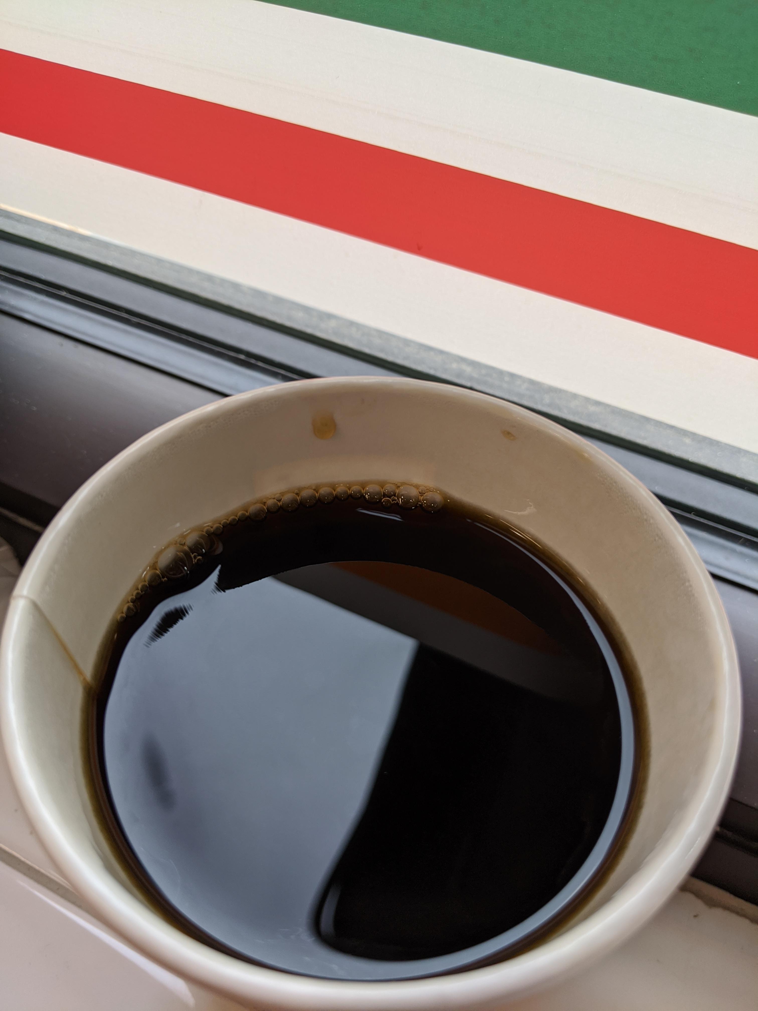 Downing a cup of hot black coffee in the back of a 7/11 before