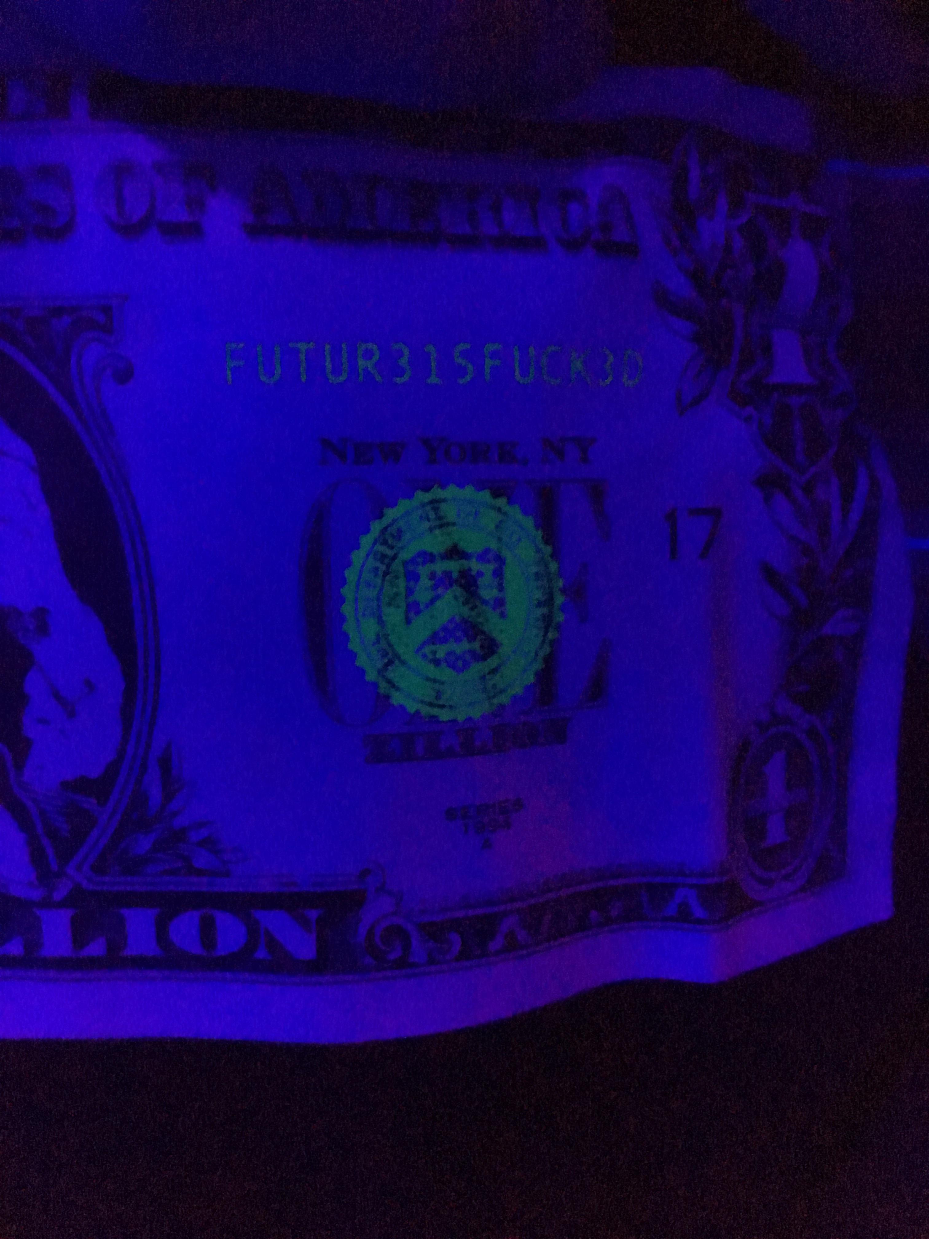 The stamps/markings on the dollar tee glow under UV light r