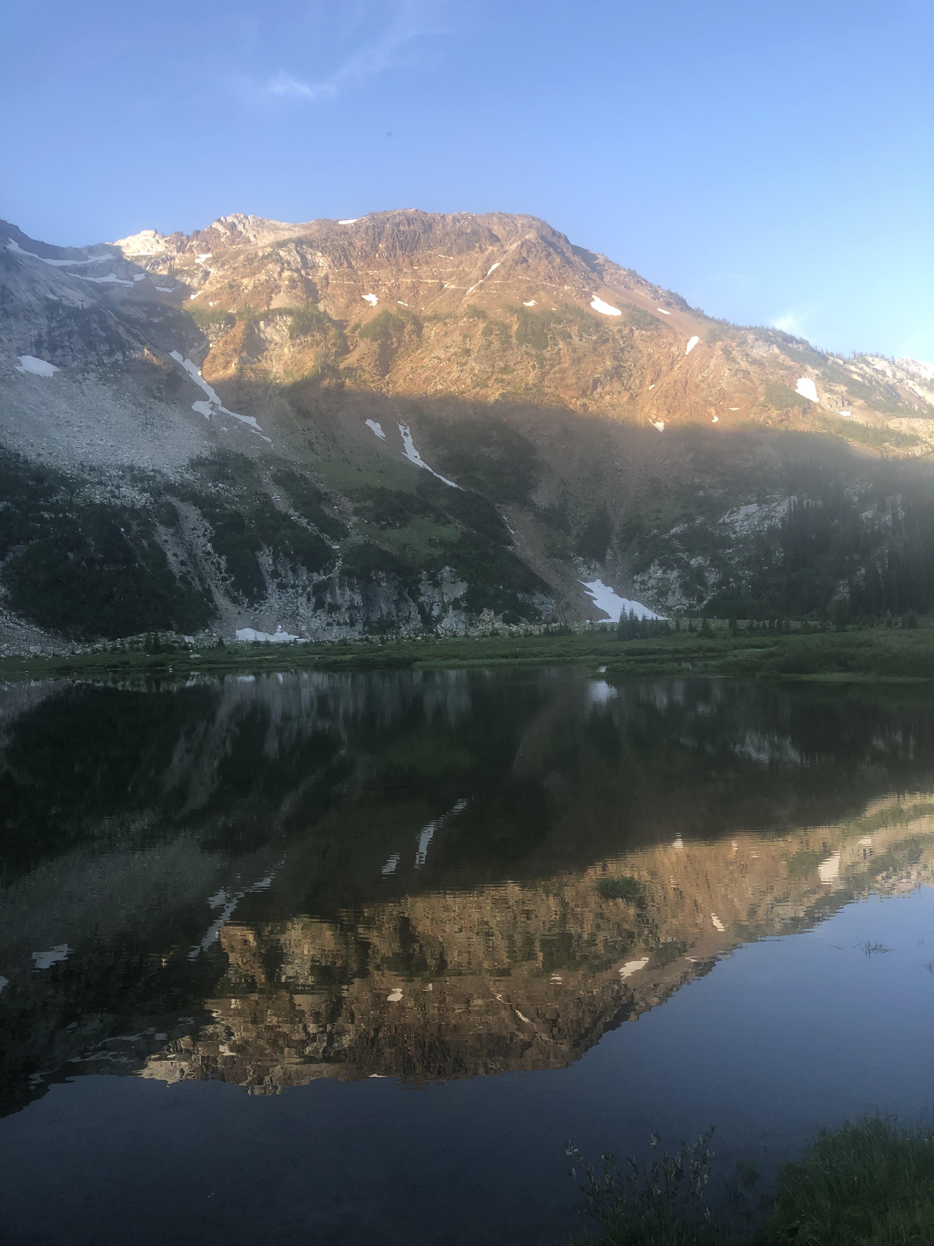 Frazier Lake reflecting sunrise on part of Cusick Mountain. Eagle Cap