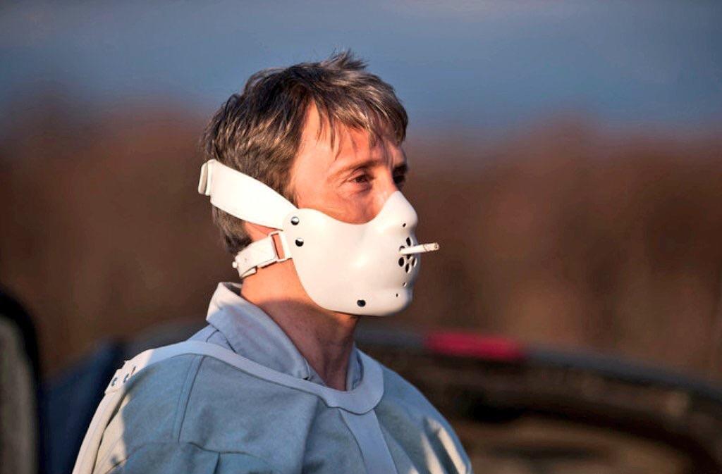 Mads Mikkelsen smoking a cigarette while wearing his Hannibal Lecter