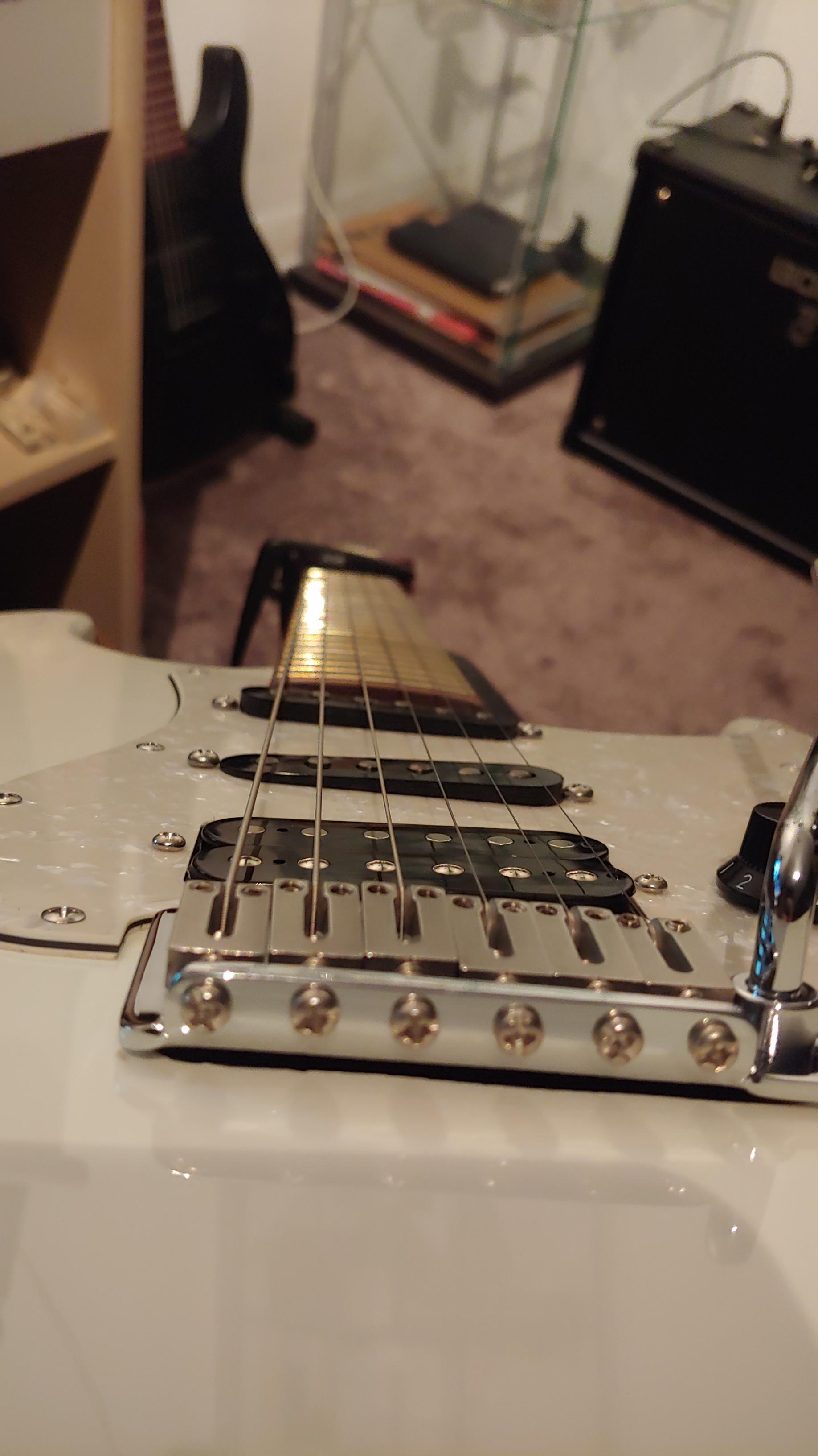 I Bought a new guitar and the bridge and middle pickup are slanted. Is