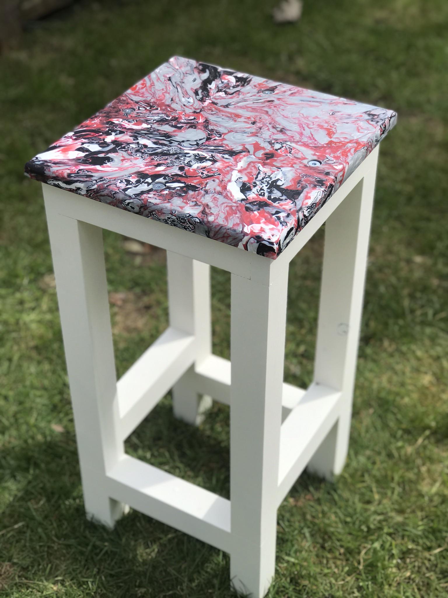 A bar stool top made using milk bottle lids and other recycled plastic