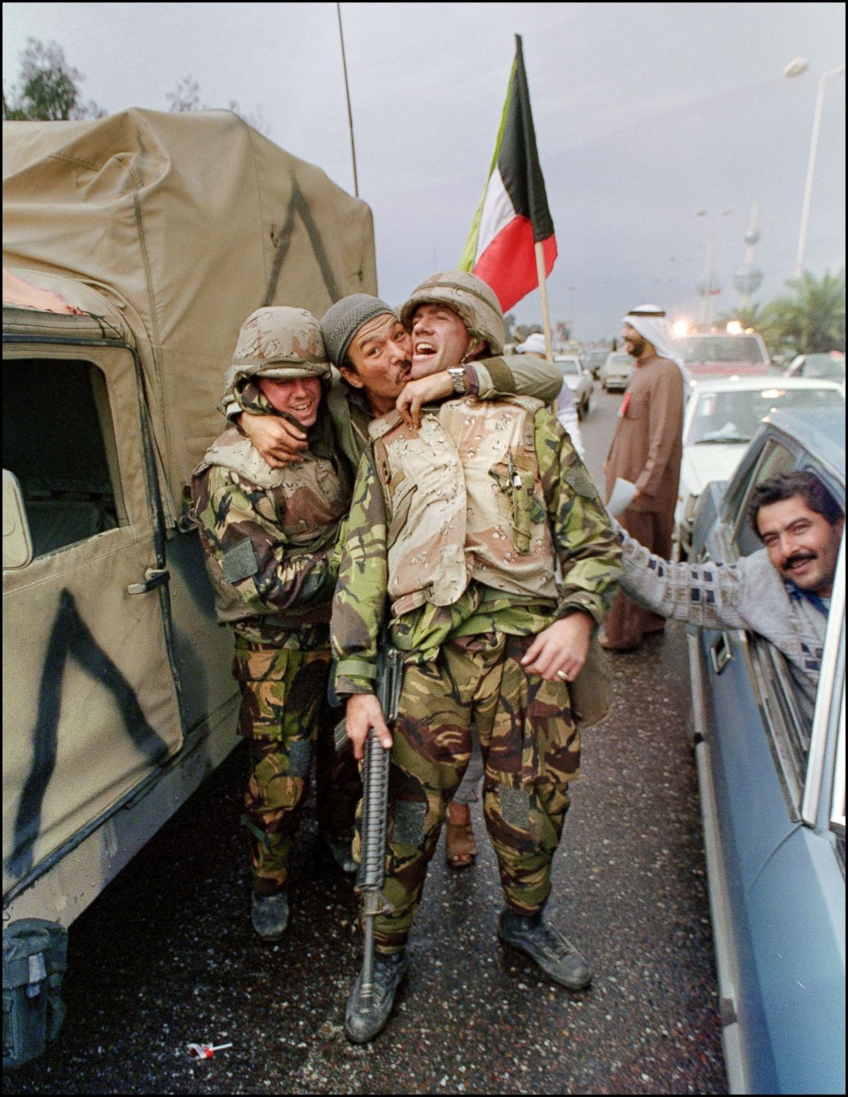 A Kuwait City resident hugs two US Marines after Allied troops liberated the capital of Kuwait