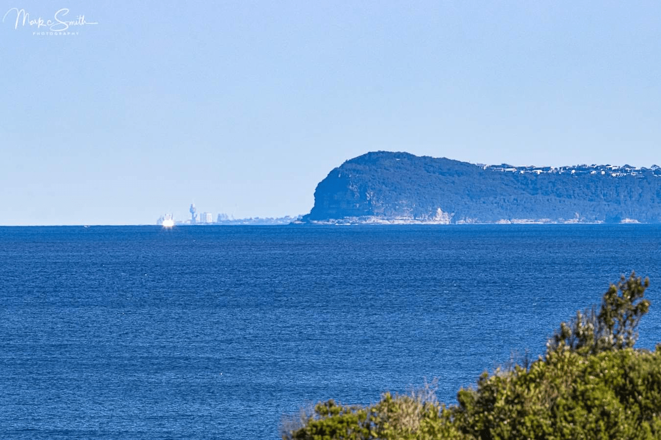 Centre Point Tower seen from Norah Head, rising above the horizon on an