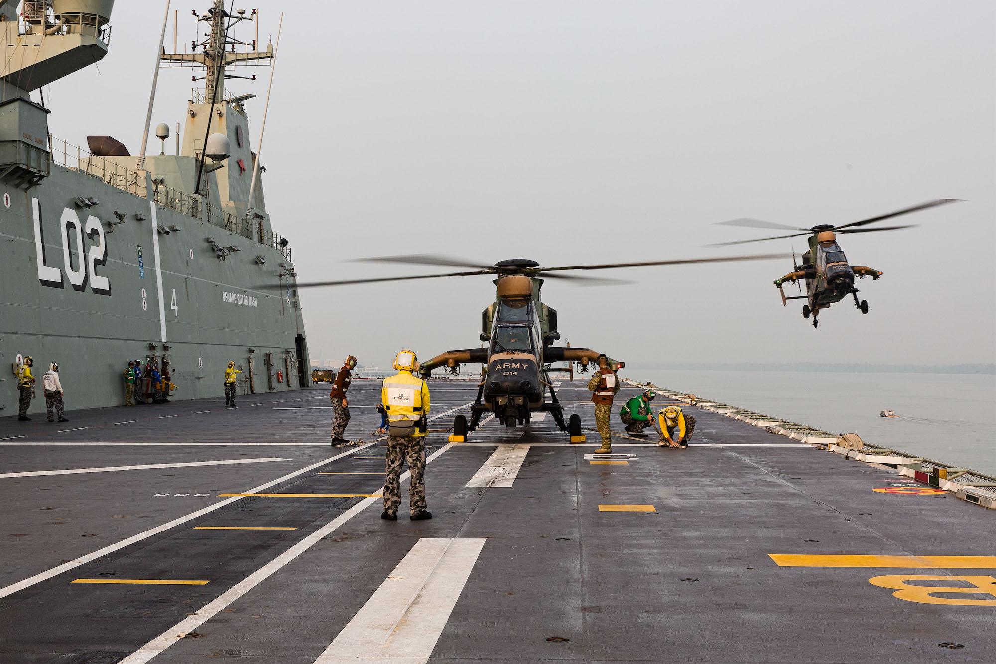An Australian Army Tiger armed reconnaissance helicopter lands on HMAS