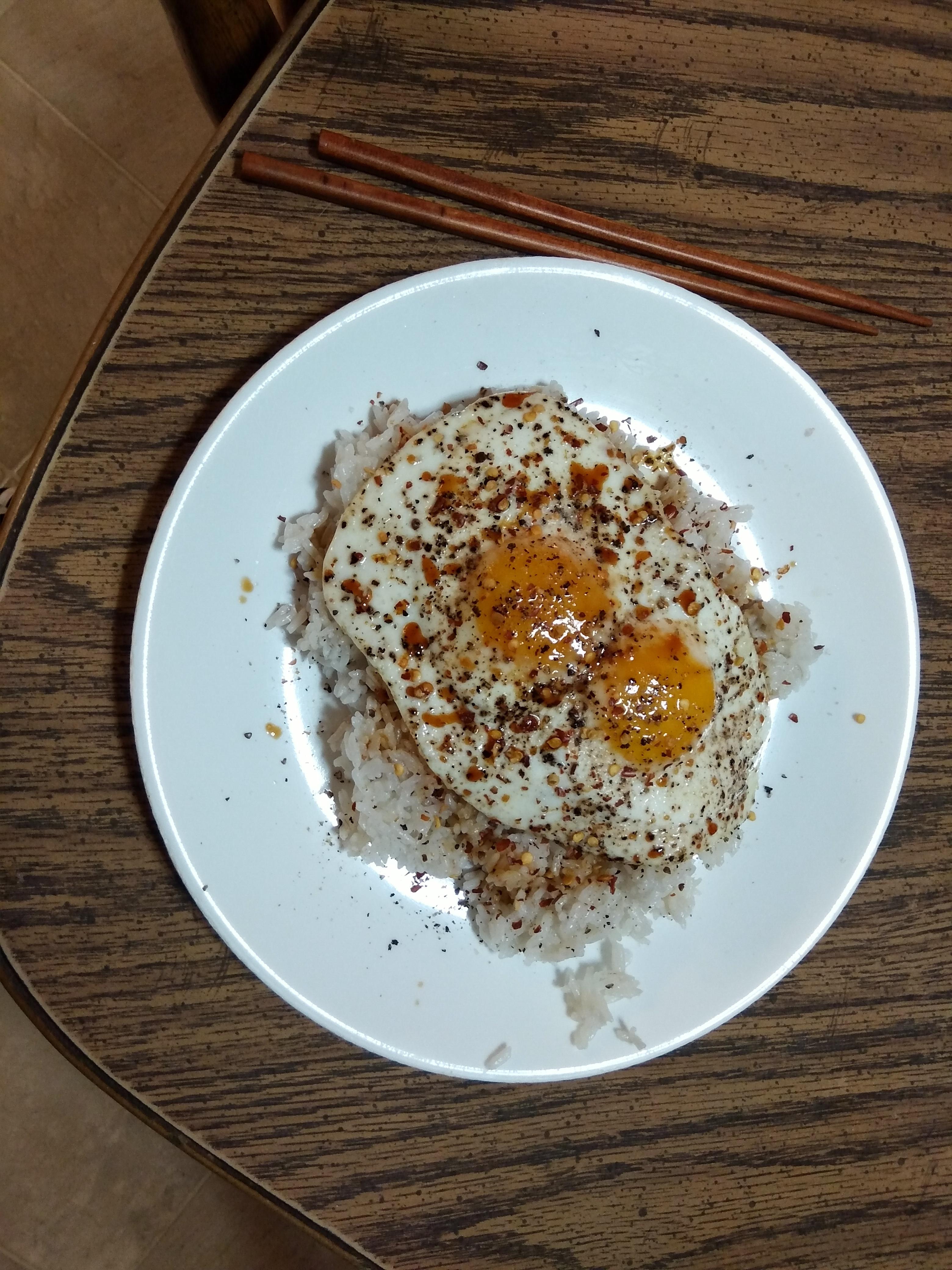 Overcooked sunny side up eggs over a bed of white rice I cooked in the instant pot. r