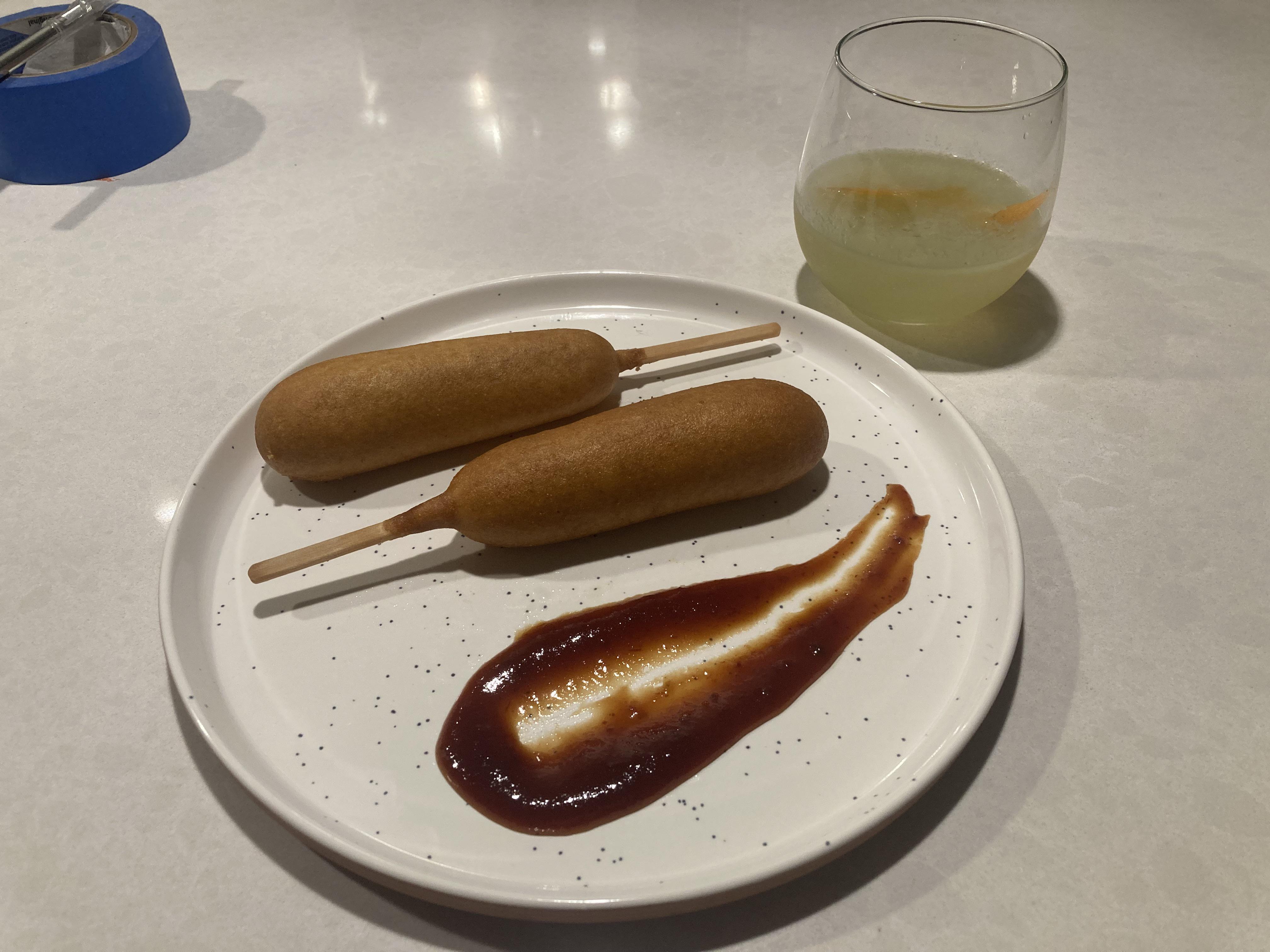 Two frozen corndogs served with BBQ sauce and a Last Word r